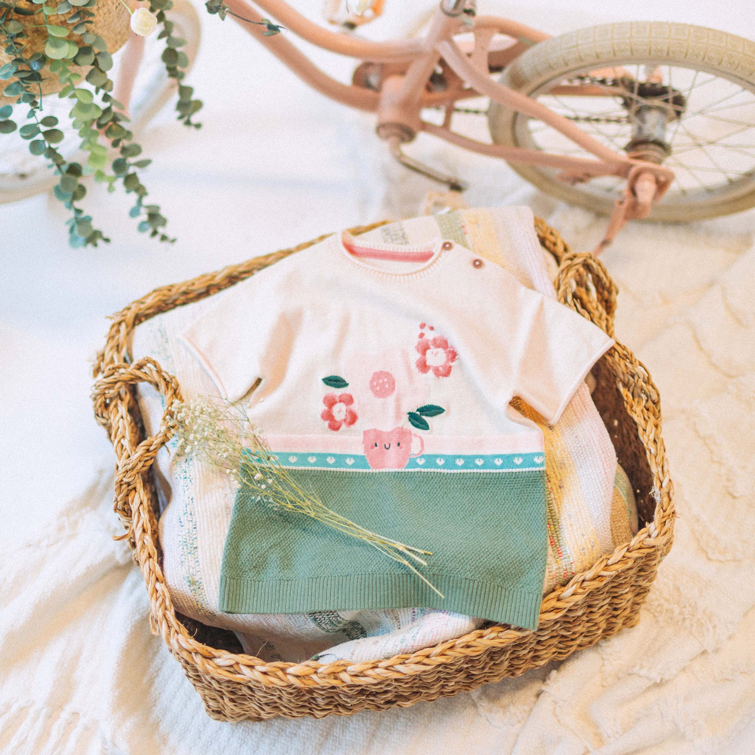 Photo créative de la robe de maille à manches courtes vert, crème et corail motif jacquard floral, bébé