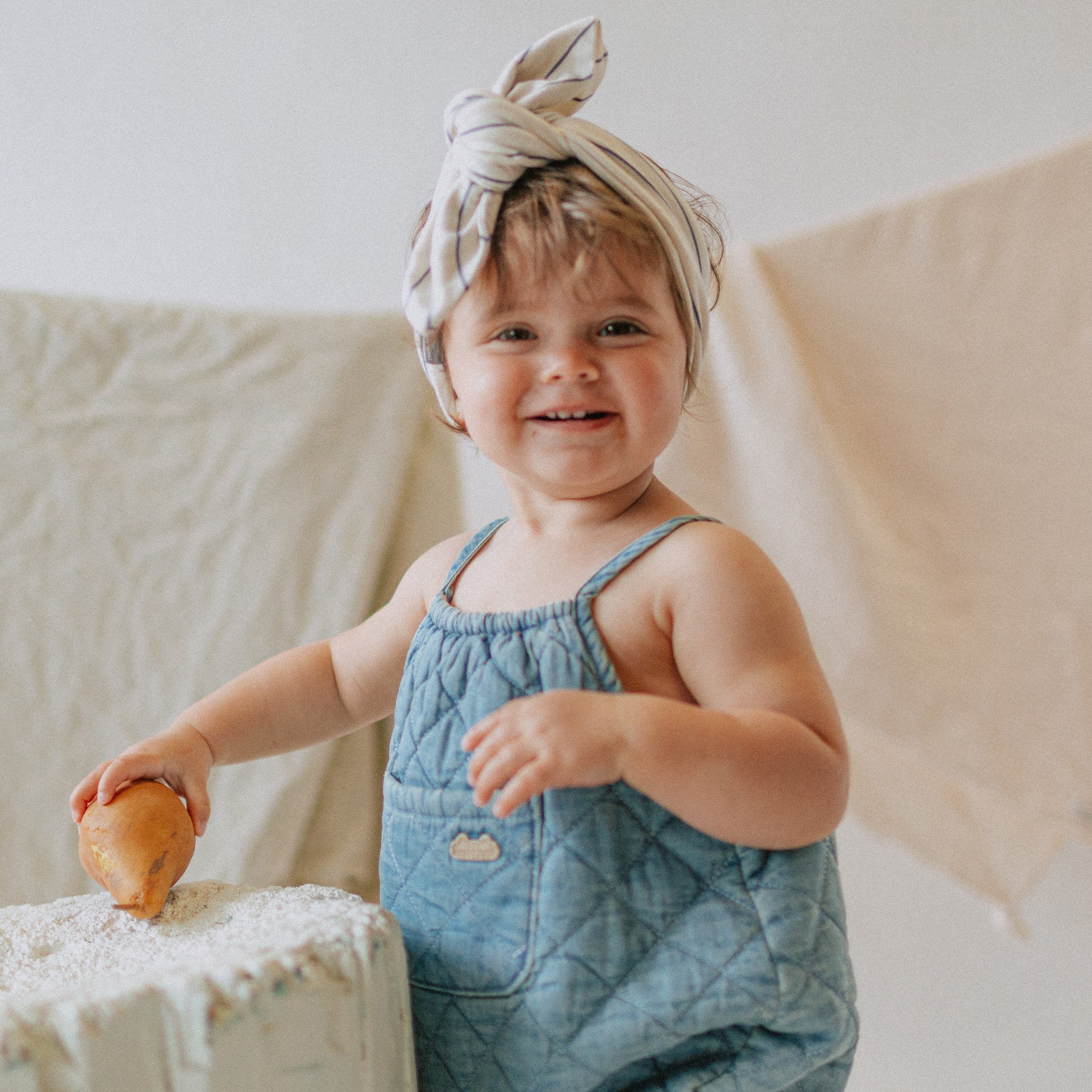 Photo d'un bébé portant le une-pièce court coupe ample en denim matelassé, naissance