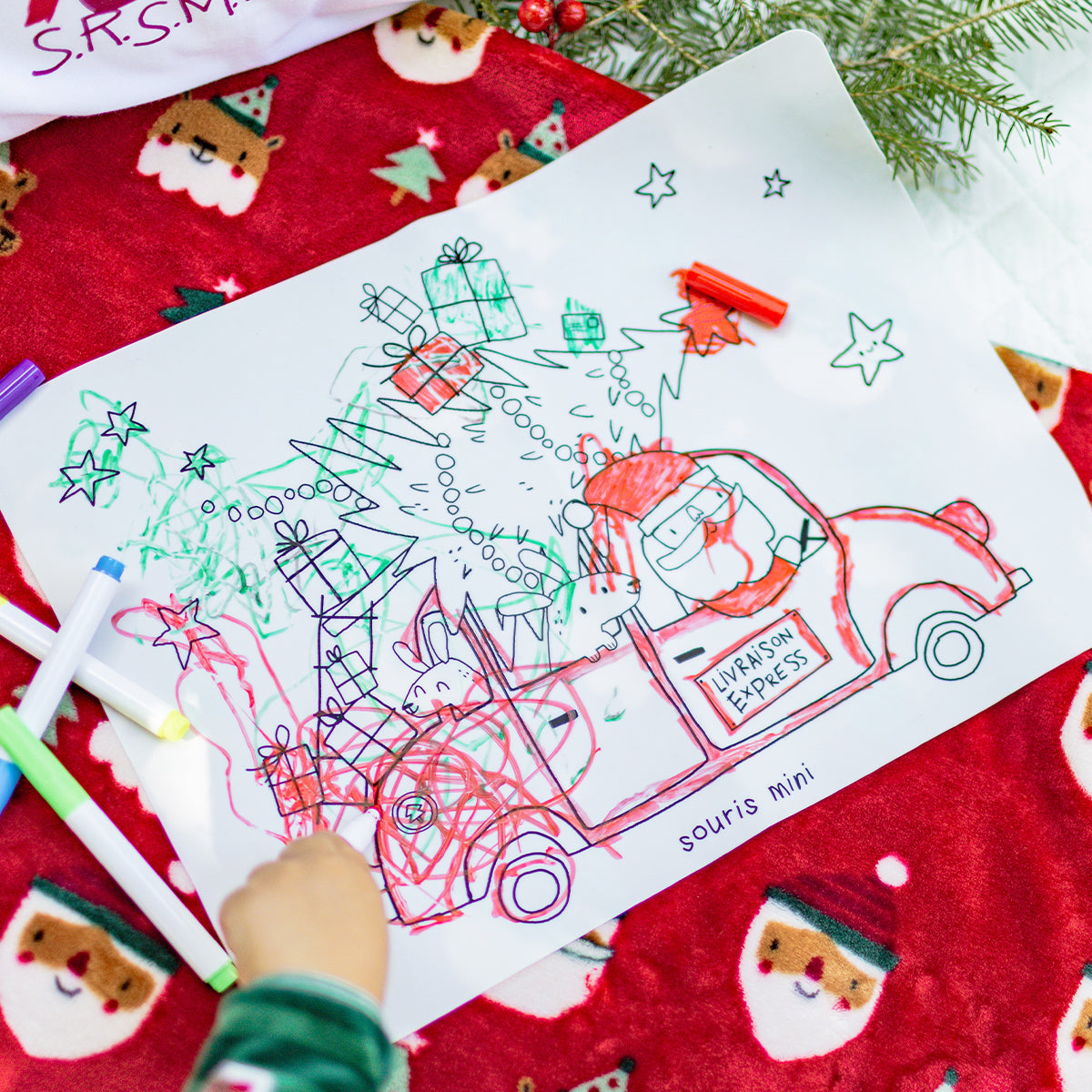 Dessin de Noël Souris Mini colorié par un enfant, représentant le Père Noël dans une voiture “Livraison Express” avec cadeaux et sapin.