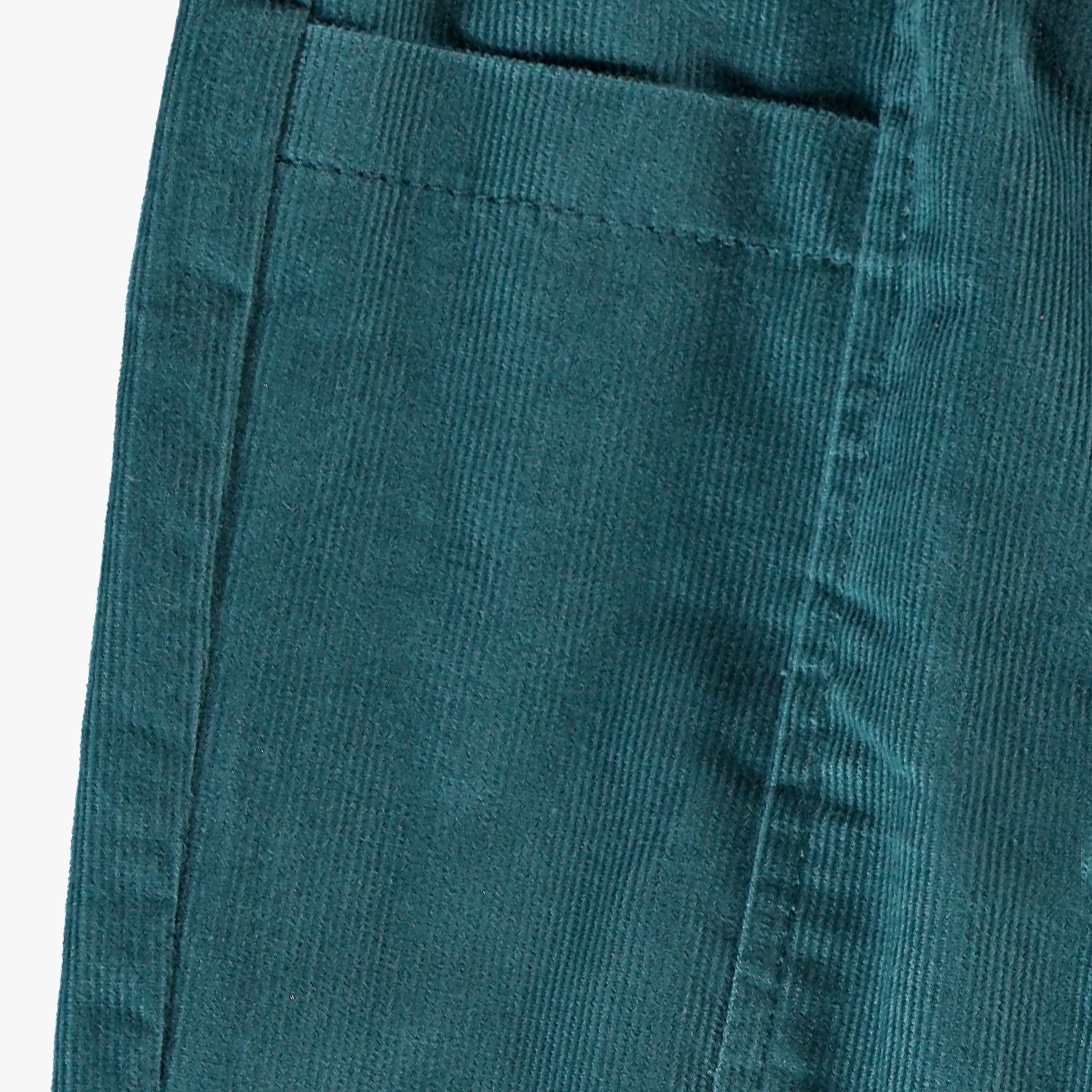 Gros plan sur la poche arrière du pantalon bébé bleu pétrole en velours côtelé fin.