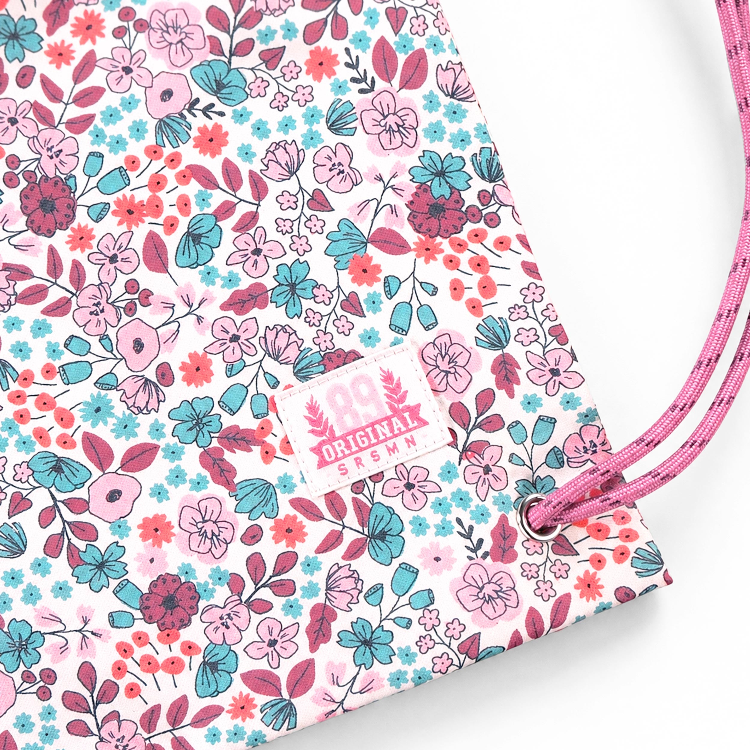 Détail imprimé floral rose et bleu sur sac à cordon enfant