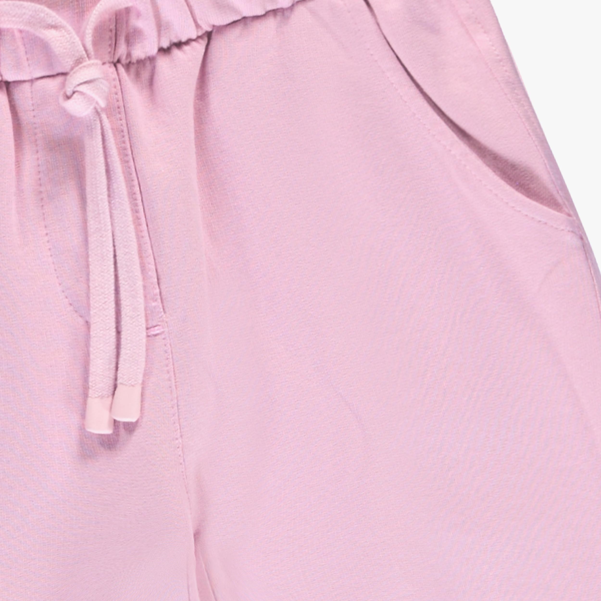 Zoom sur ceinture élastique, cordon de serrage et poche d’un pantalon enfant fille rose confortable