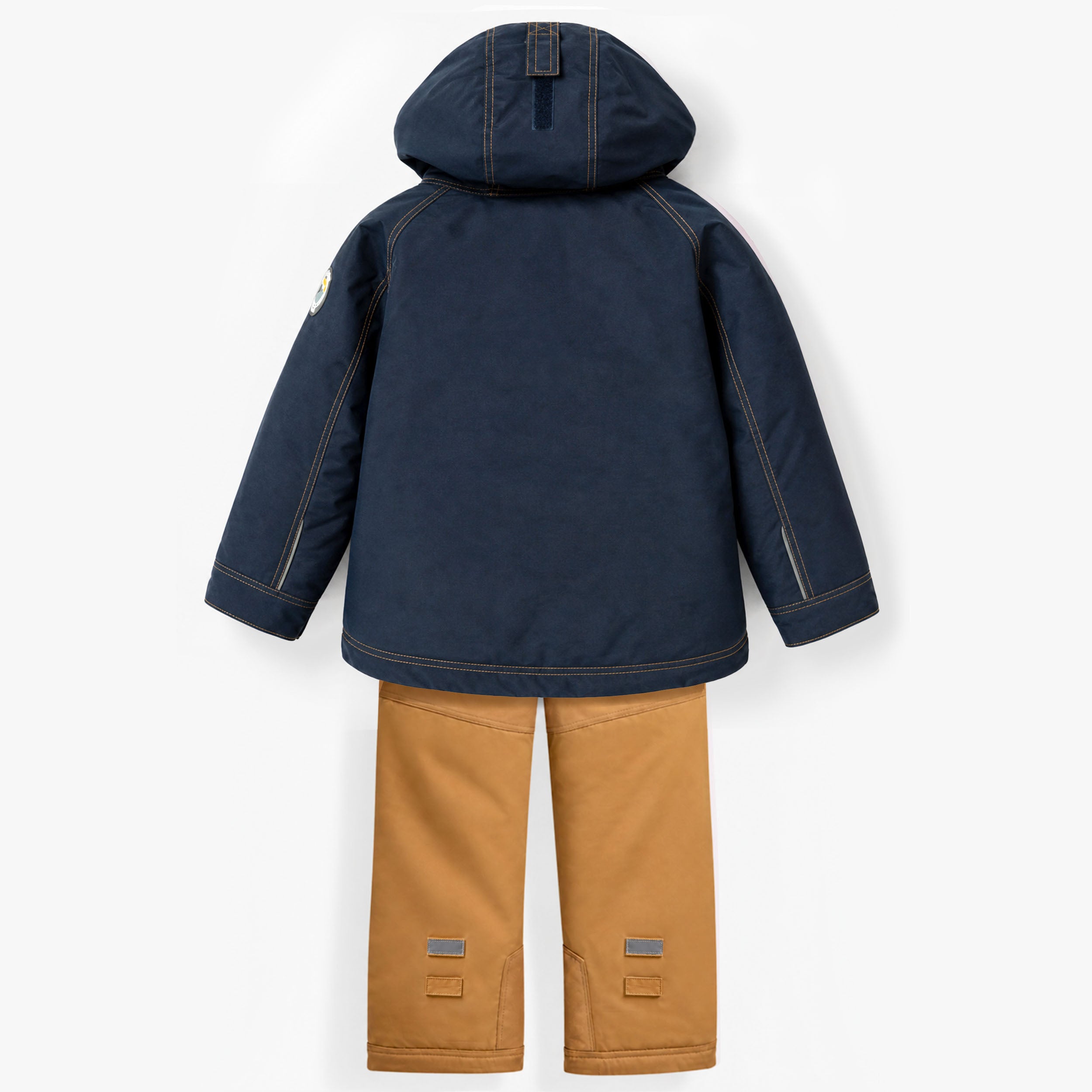 Ensemble de neige pour enfant vu de dos avec manteau d’hiver bleu marine à capuchon et pantalon isolé camel doté de détails réfléchissants.