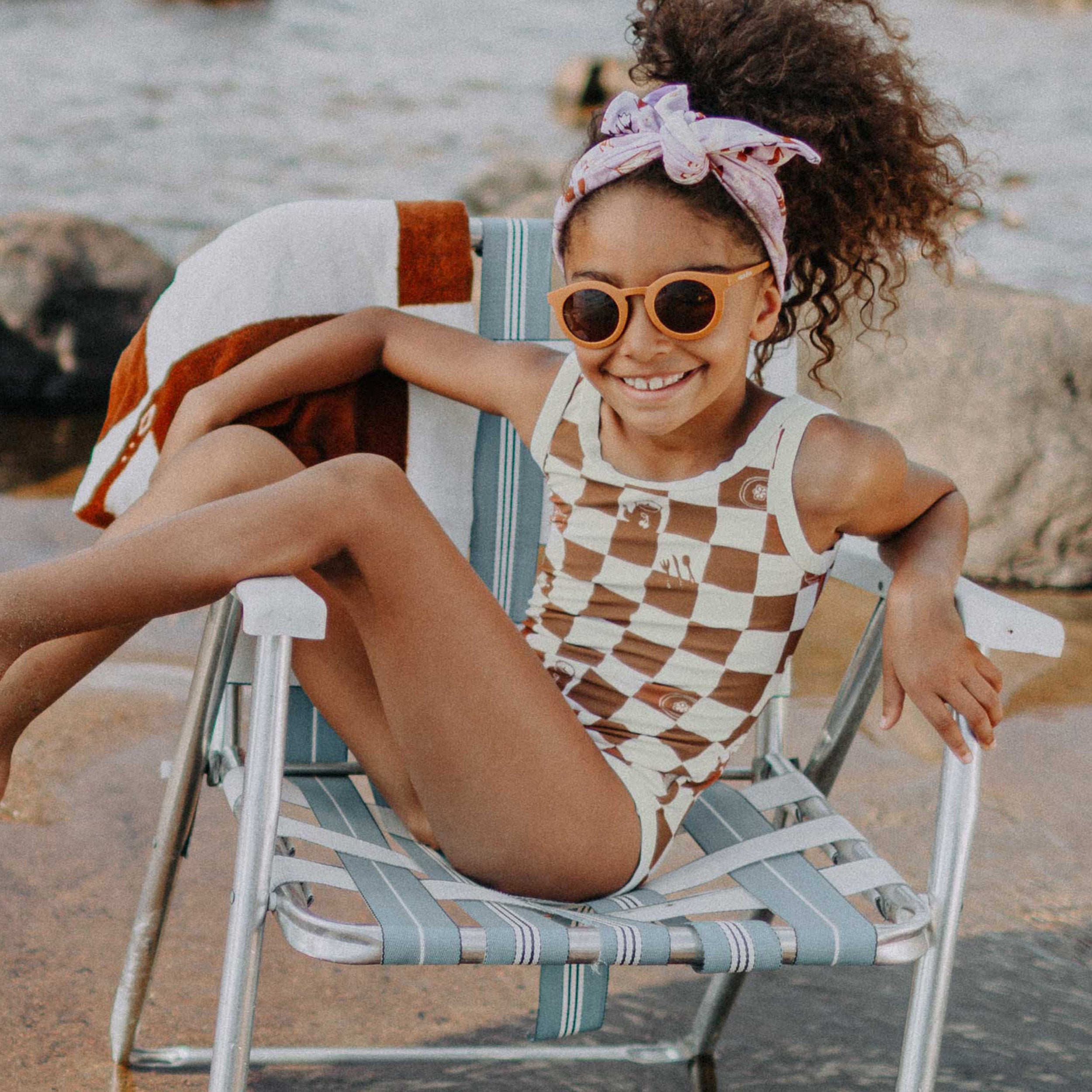 Photo d'un enfant portant le maillot de bain une pièce crème et brun à carreaux, enfant
