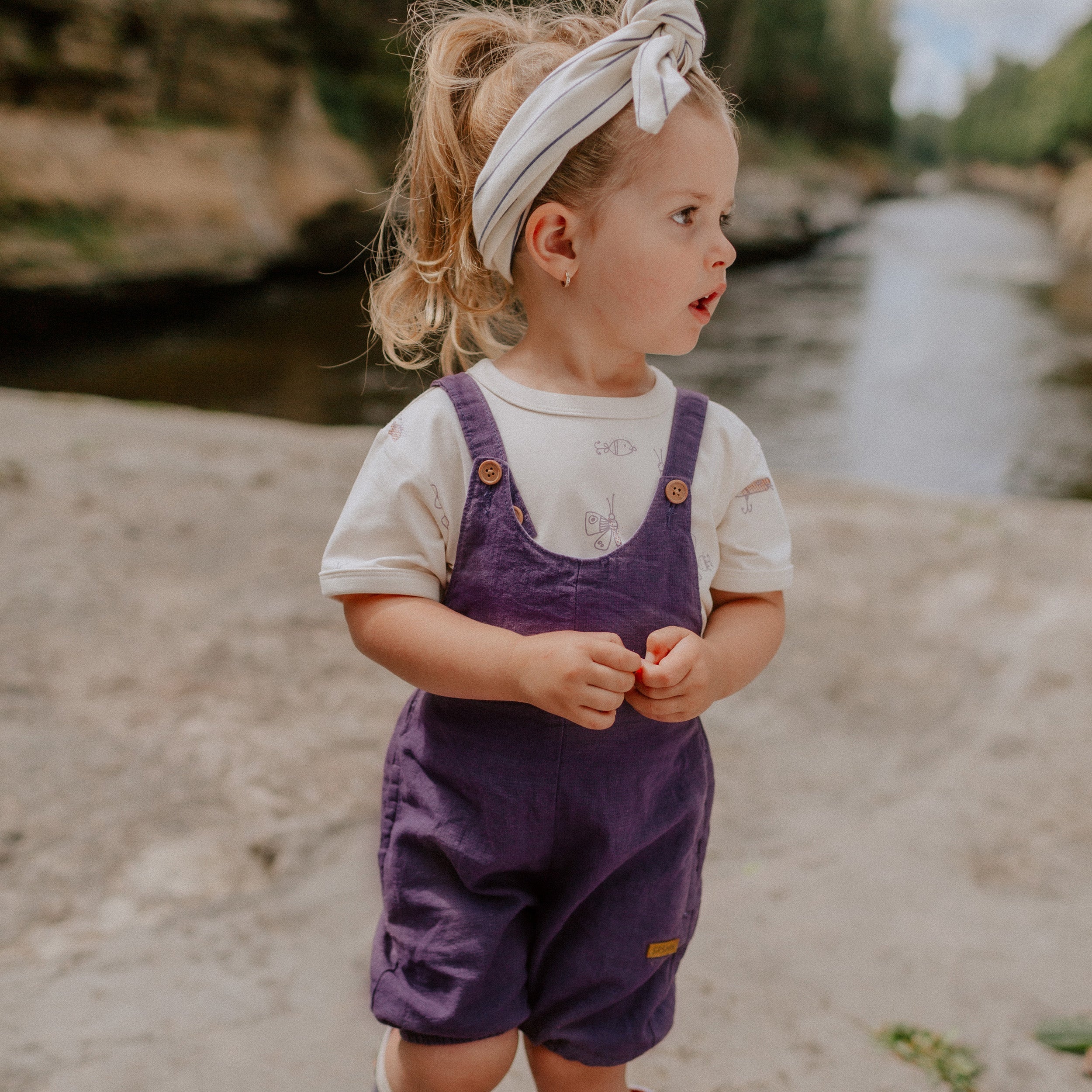 Photo d'un bébé portant la salopette mauve ample en lin, bébé