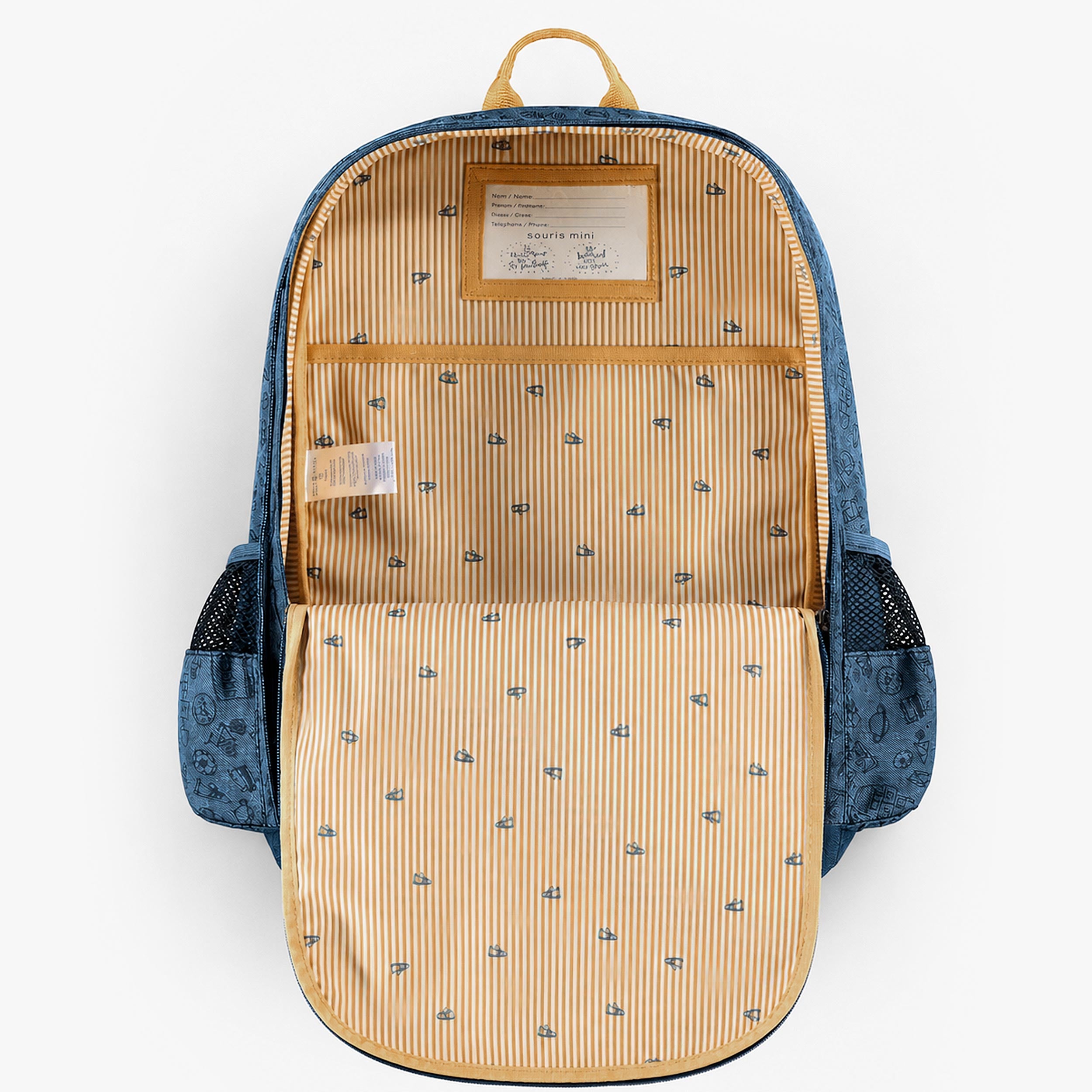 Intérieur ouvert d’un sac à dos enfant bleu avec doublure rayée jaune, poche de rangement et étiquette d’identification.