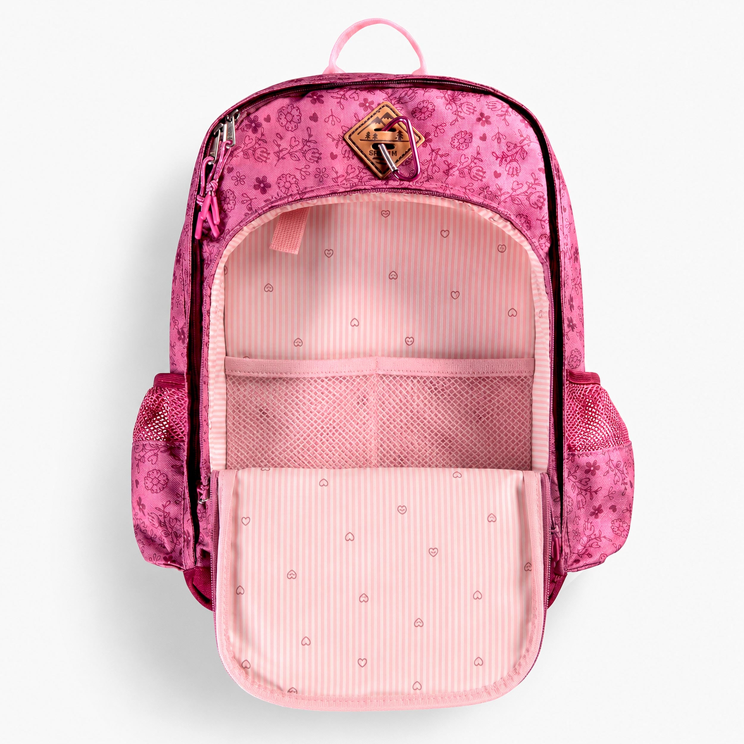 Intérieur d’un sac à dos enfant rose à motif floral avec compartiments de rangement et poche filet intégrée.