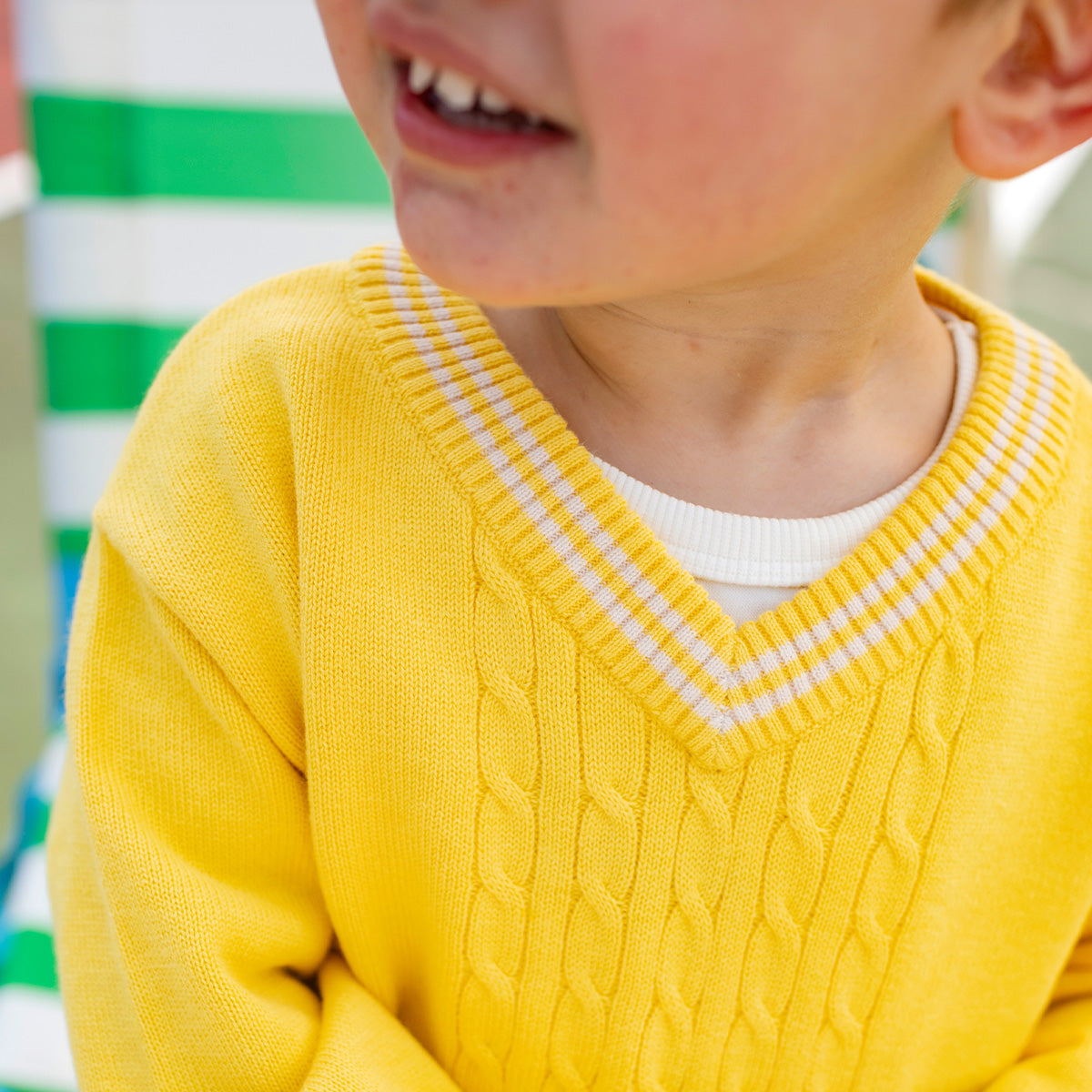 Détail du chandail en tricot jaune col V, bébé