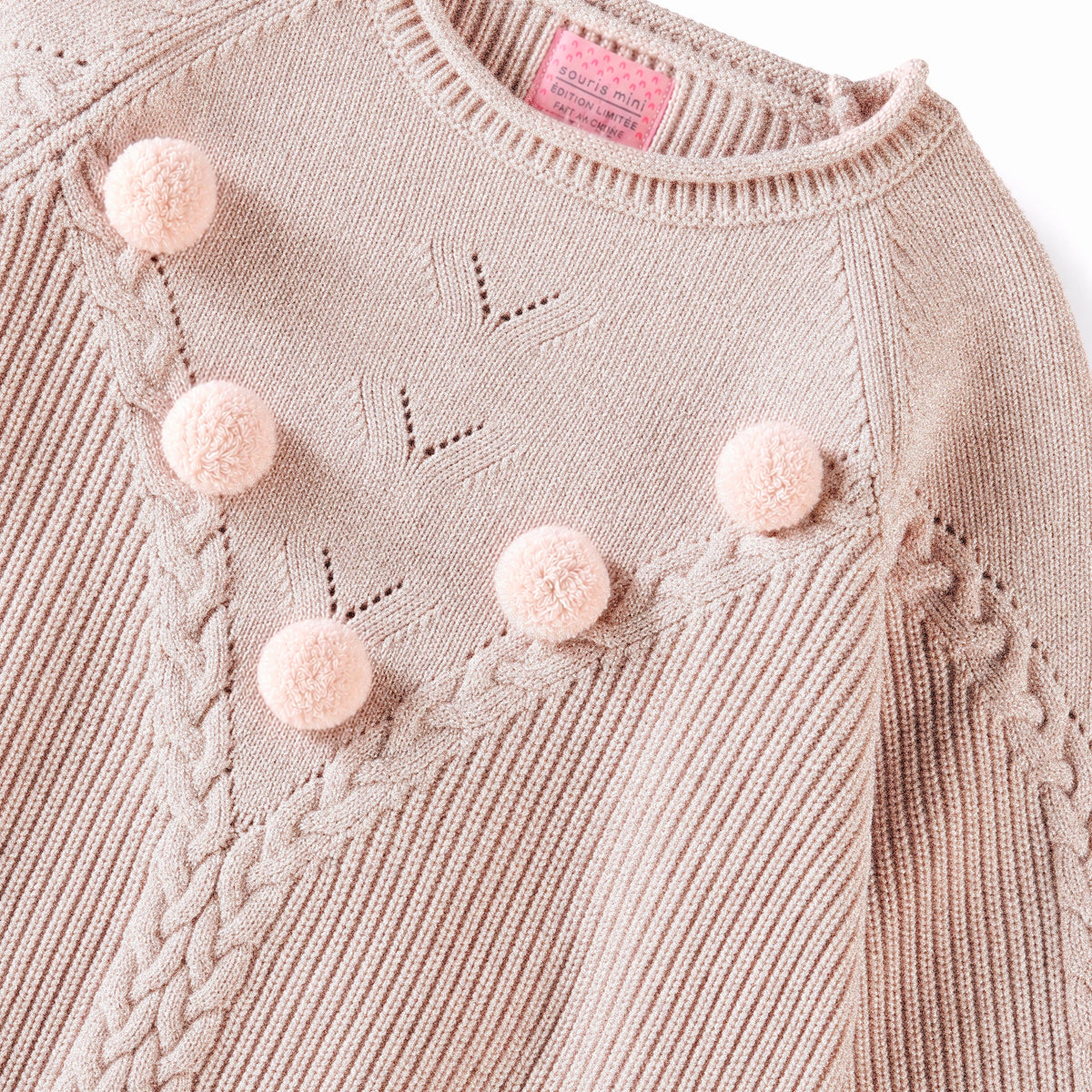 Pink knit sweater with pom-poms and cable details, child
