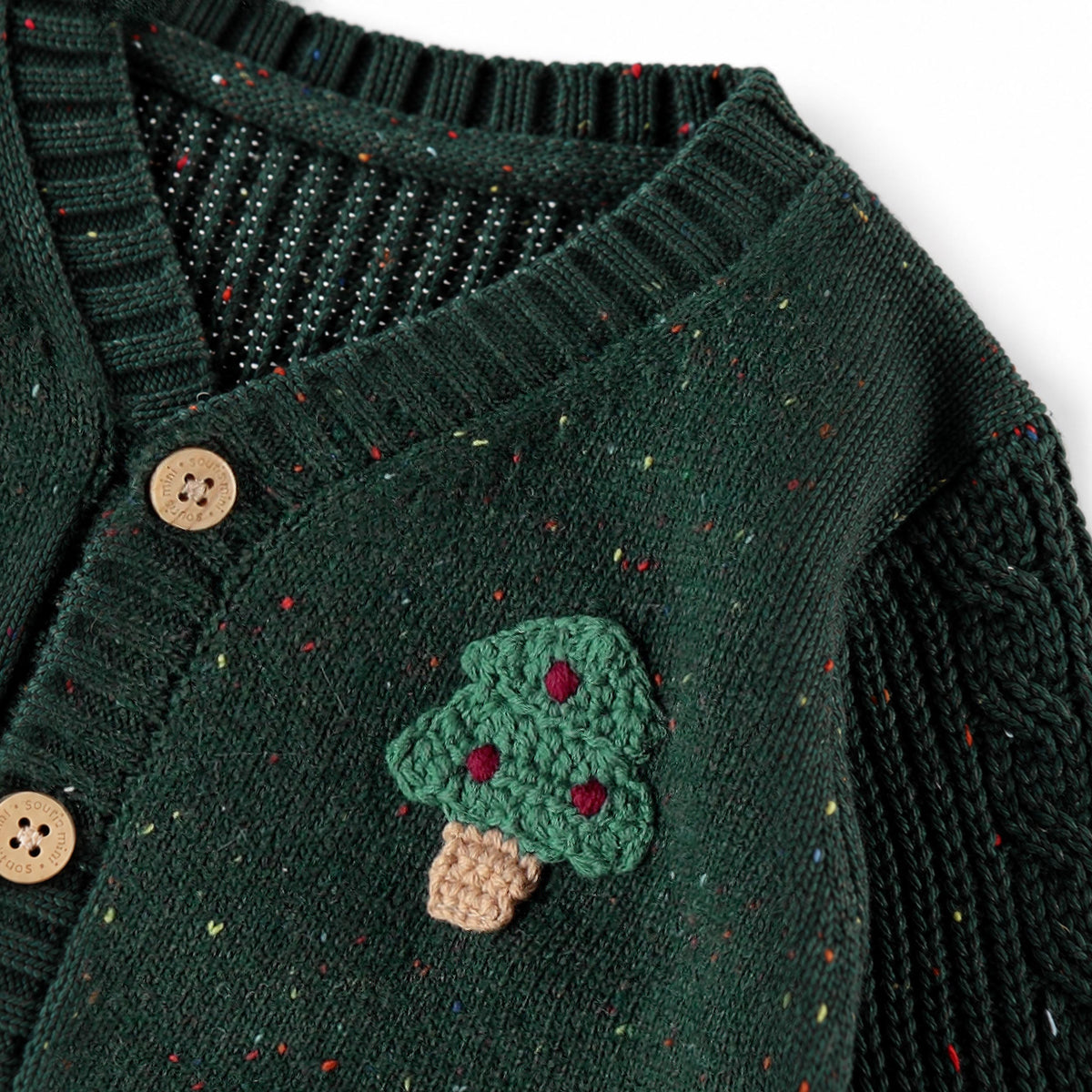 Cardigan vert forêt en tricot moucheté avec sapins, naissance