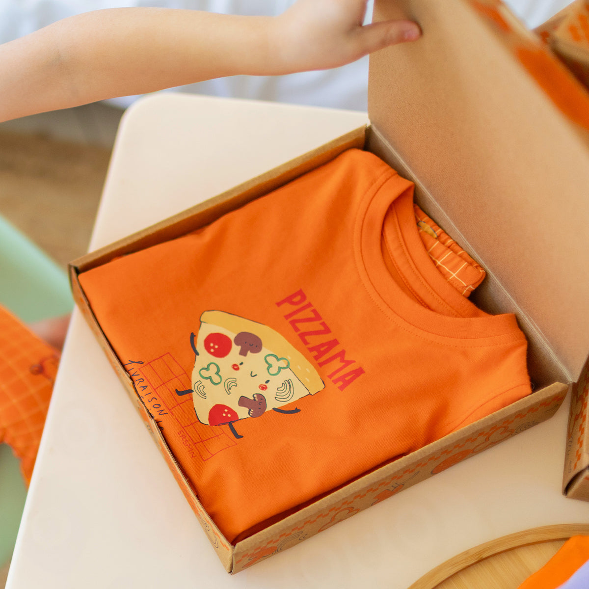 Orange two-piece pajamas with pizza patterns, baby