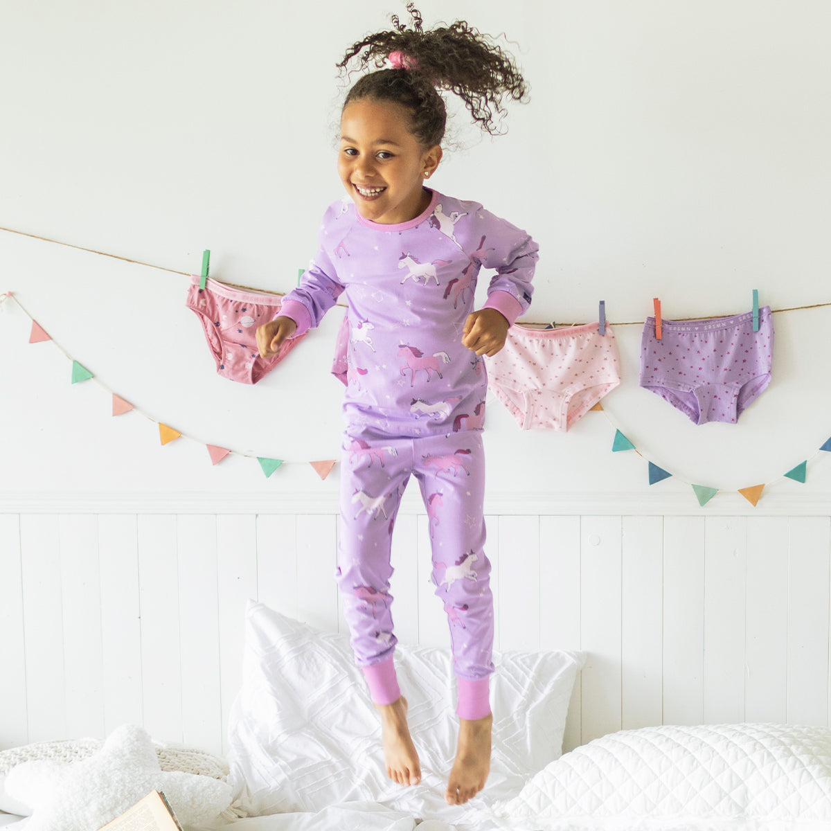 Photo d'un enfant portant le pyjama deux pièces mauve à motifs de licornes, enfant