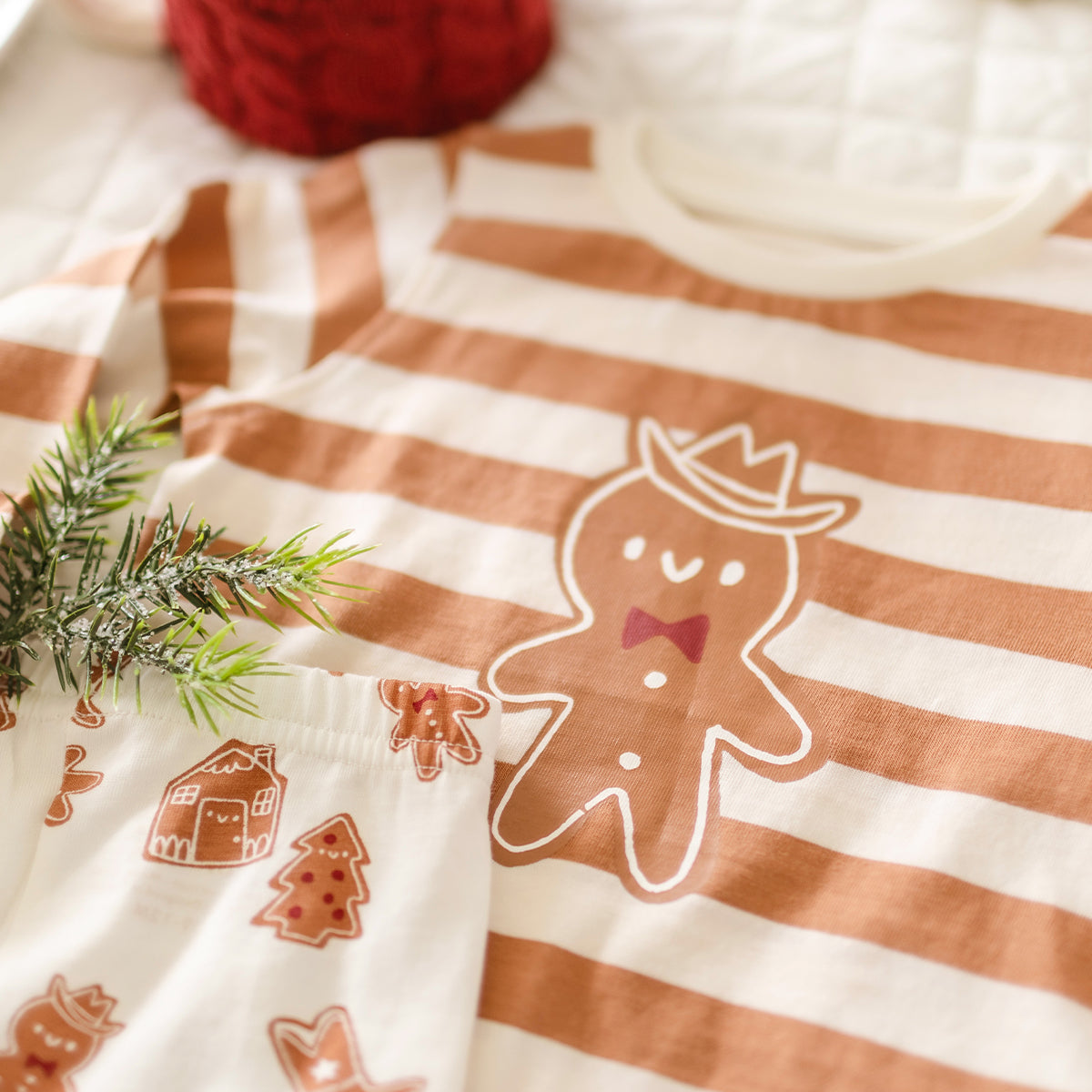 Présentation du pyjama deux pièces crème à rayures et motifs pain d’épices, bébé