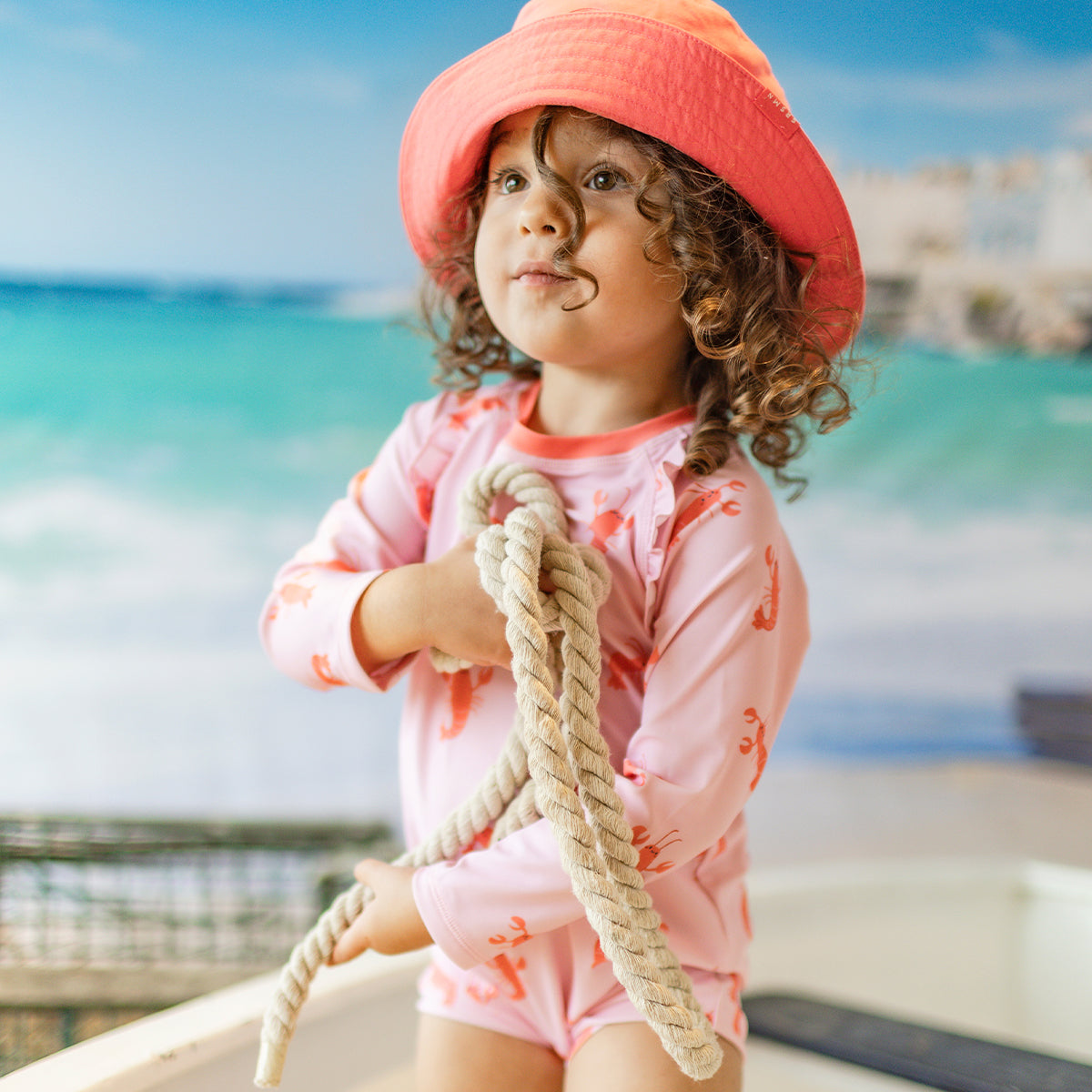 Pink one-piece swimsuit with lobster patterns, baby