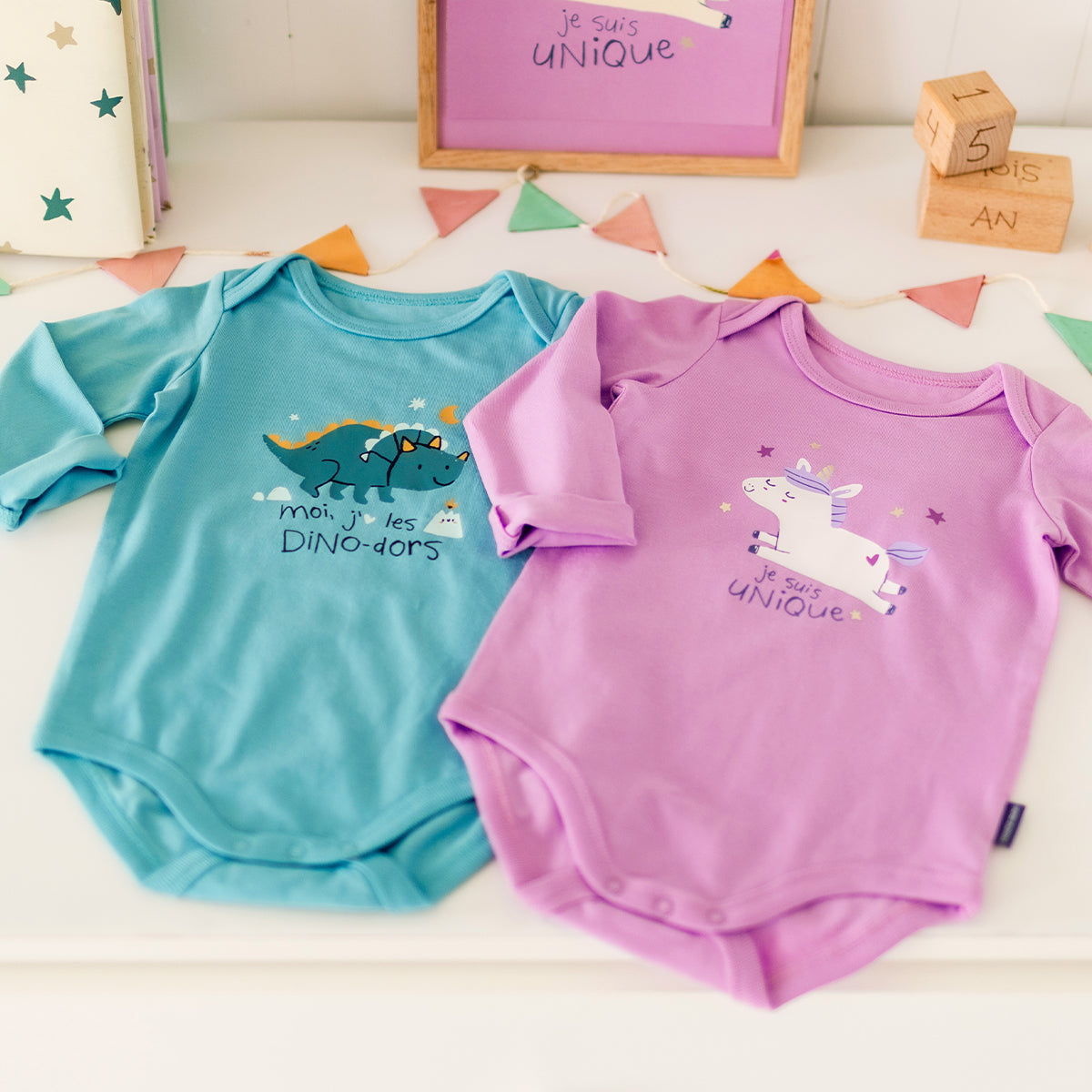 Présentation du cache-couche turquoise avec illustration de dinosaure, bébé