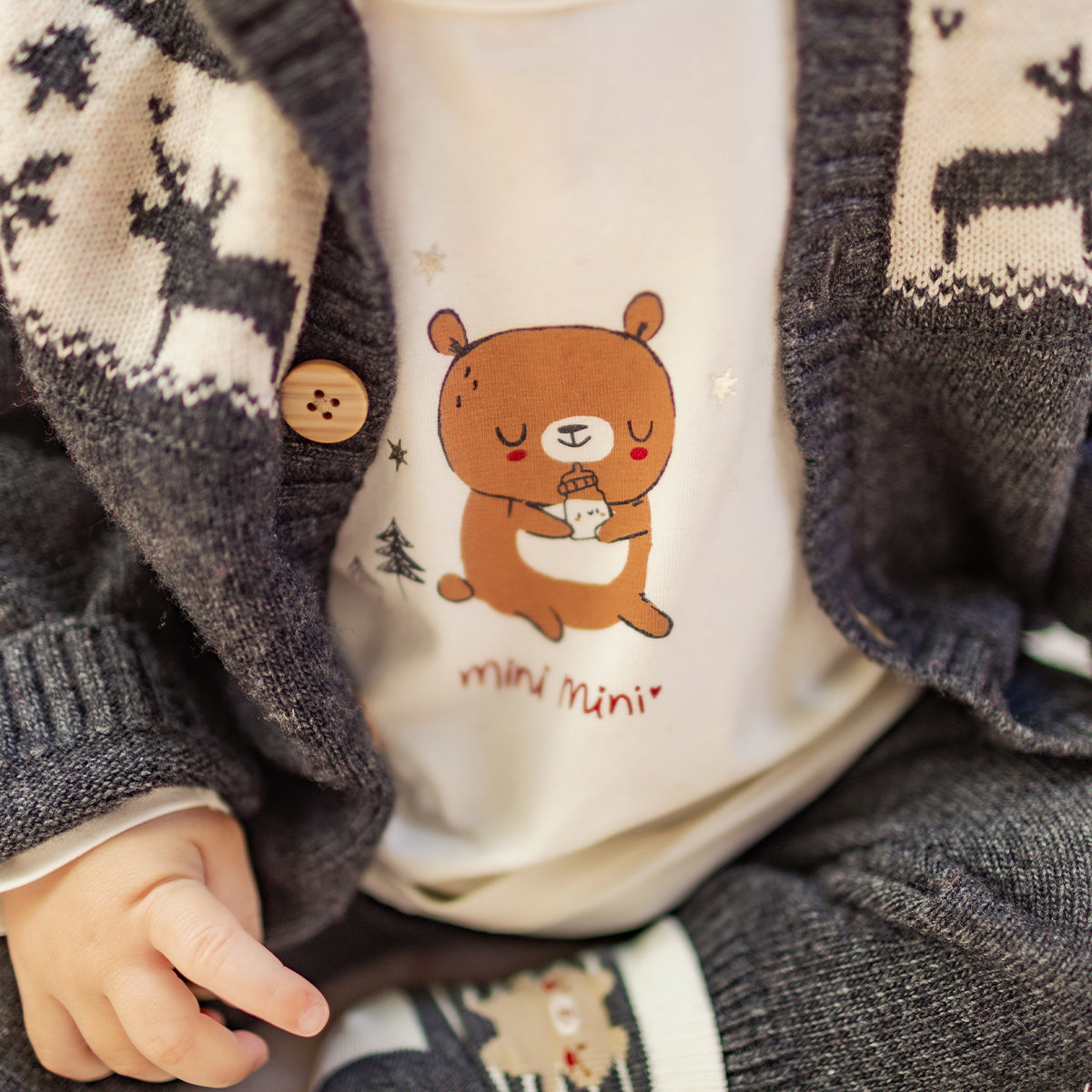 Zoom d'un bébé portant le t-shirt crème avec illustration, naissance