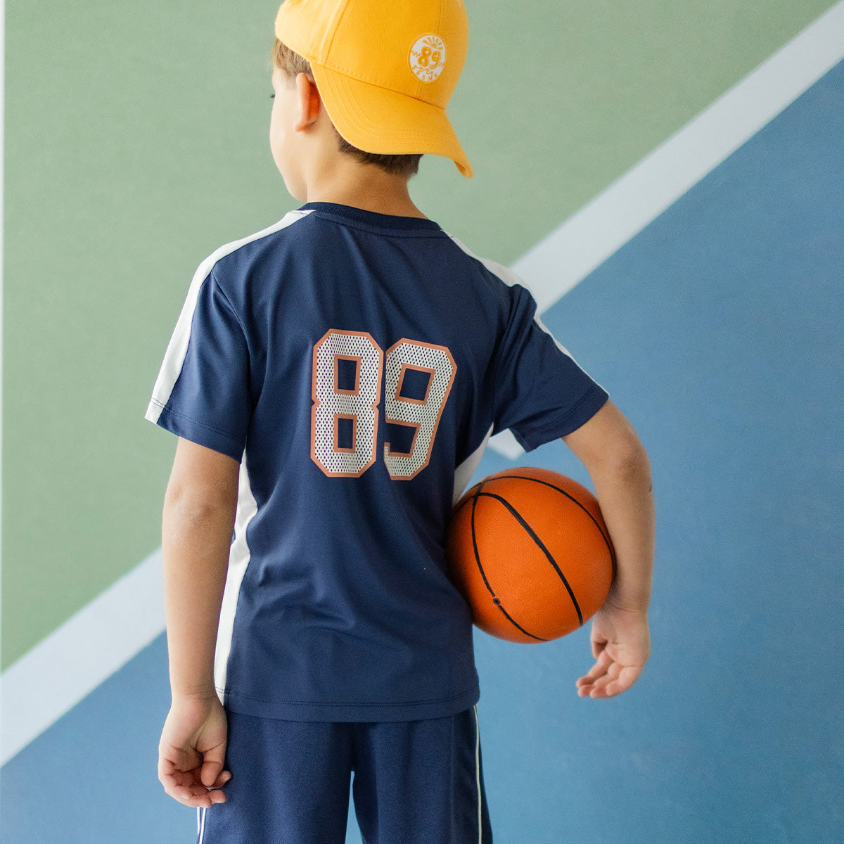 Photo de dos d'un enfant portant le t-shirt de sport bleu marine, enfant