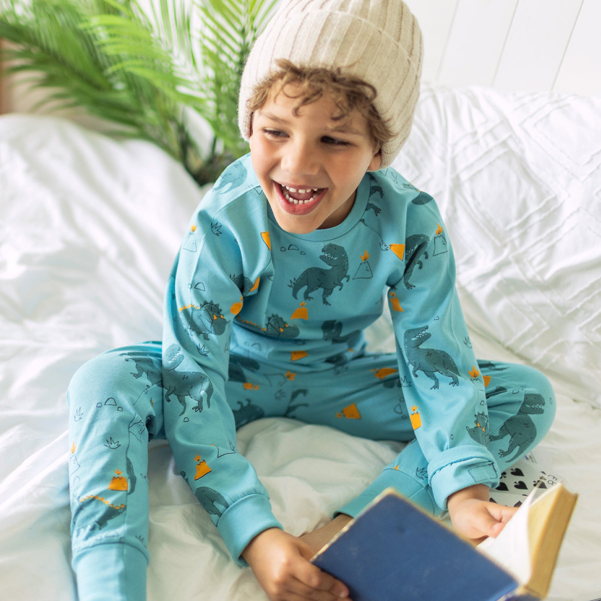 Photo d'un enfant portant le pyjama deux pièces turquoise à motifs de dinosaures, enfant
