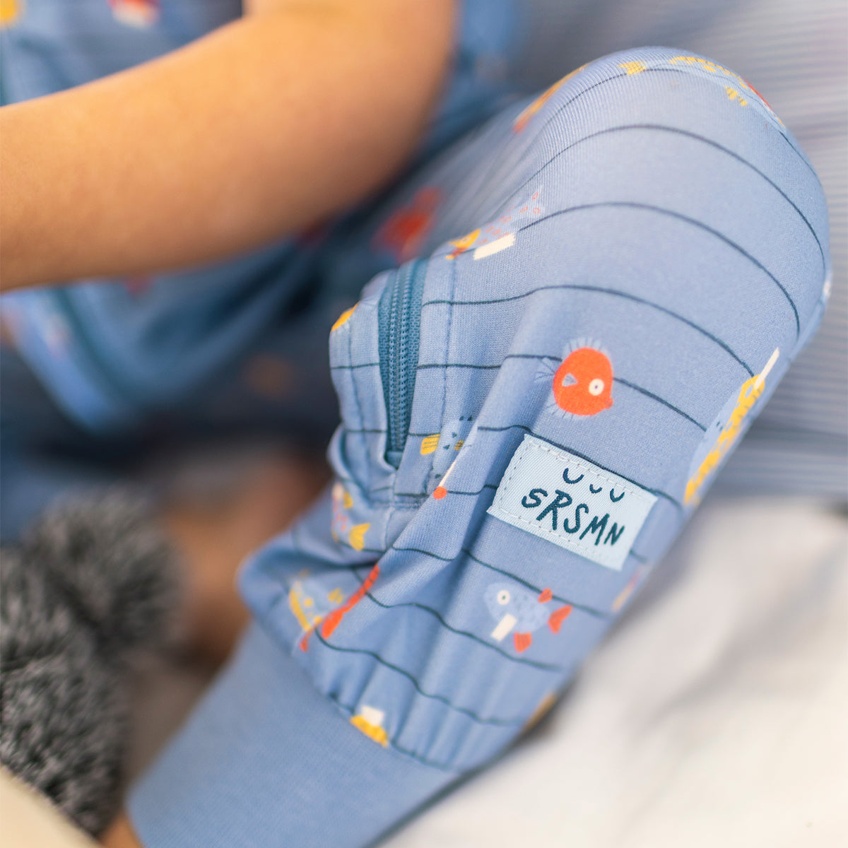 Blue one-piece pajamas with stripes and fish patterns, baby