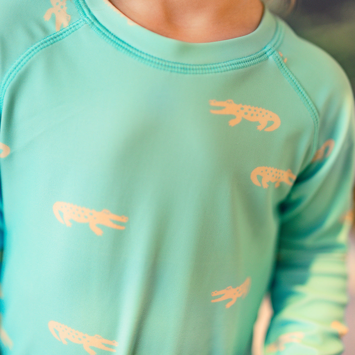 Turquoise one-piece swimsuit with crocodile patterns, baby