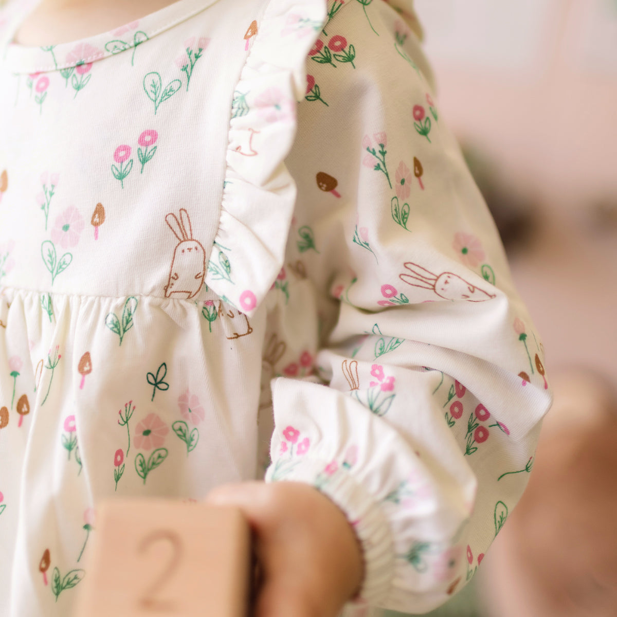 Zoom d'un bébé portant la robe crème à motifs, naissance