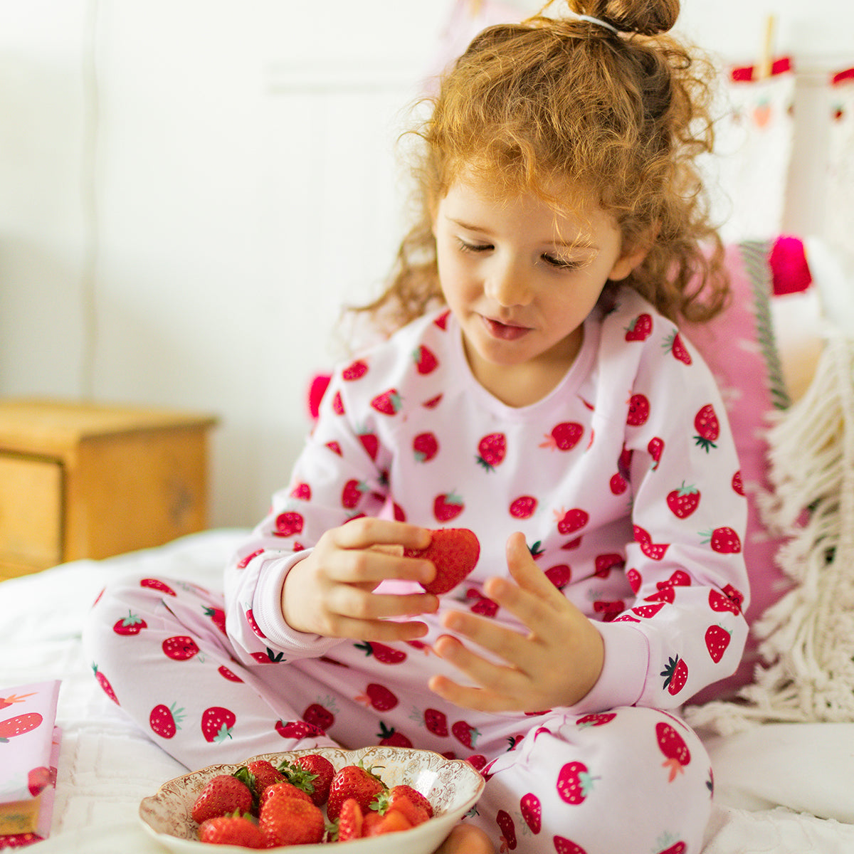 Pink two-piece pajamas with strawberry pattern, child