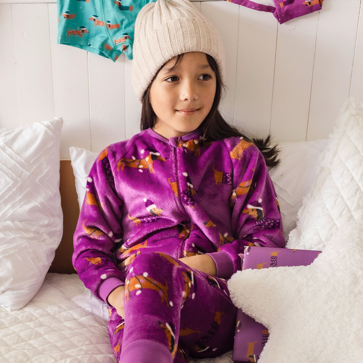 Image d'un enfant portant le pyjama une pièce mauve à motifs de chiens, enfant