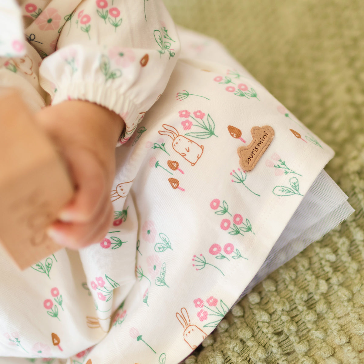 Zoom d'un bébé portant la robe crème à motifs, naissance
