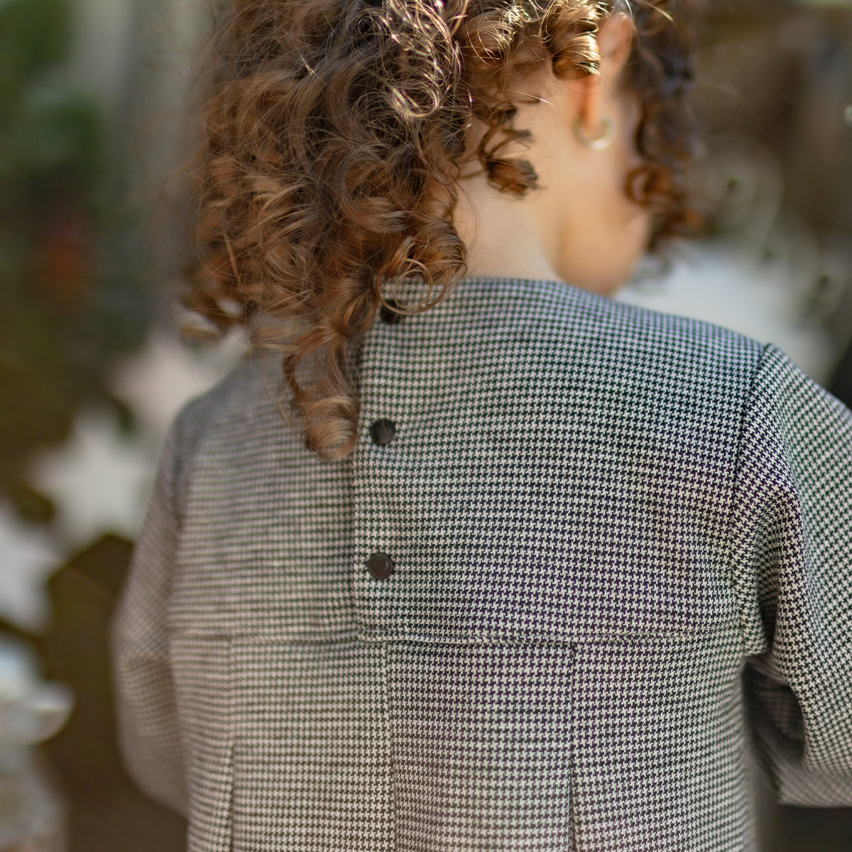 Photo de dos d'un bébé portant la robe à motif pied-de-poule, bébé