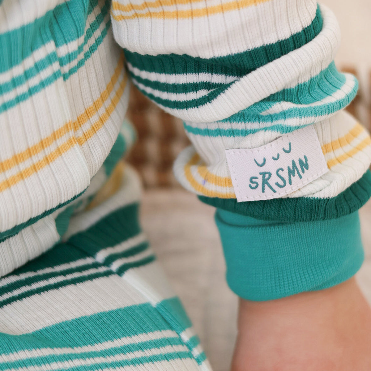 One-piece cream pajamas with colorful stripes, baby