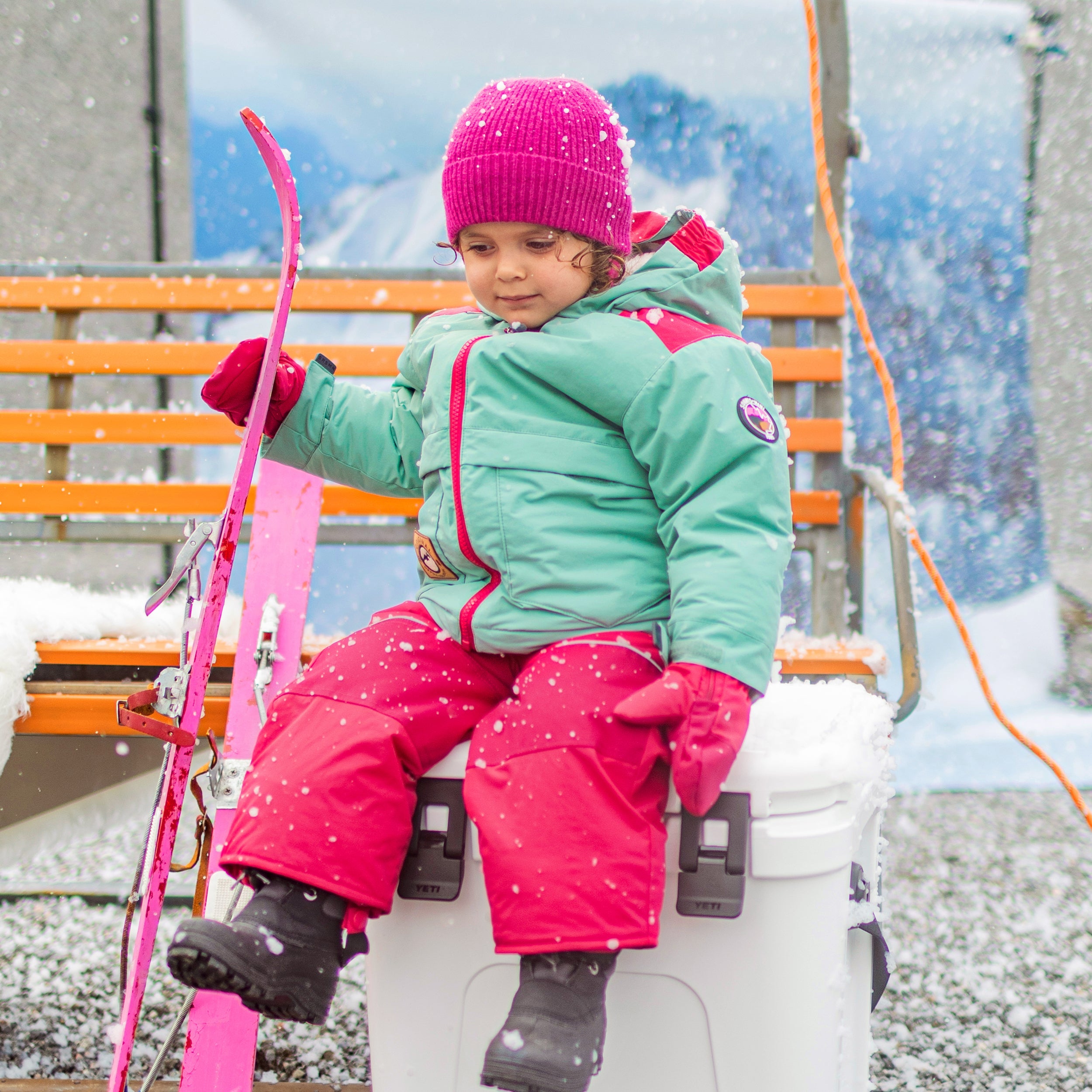Photo d'un enfant portant la tuque en tricot rose fuchsia avec cordons, bébé