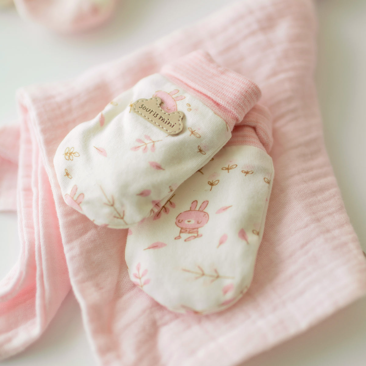 Présentation des mitaines de l’ensemble doudou, mitaines et pantoufles rose, naissance