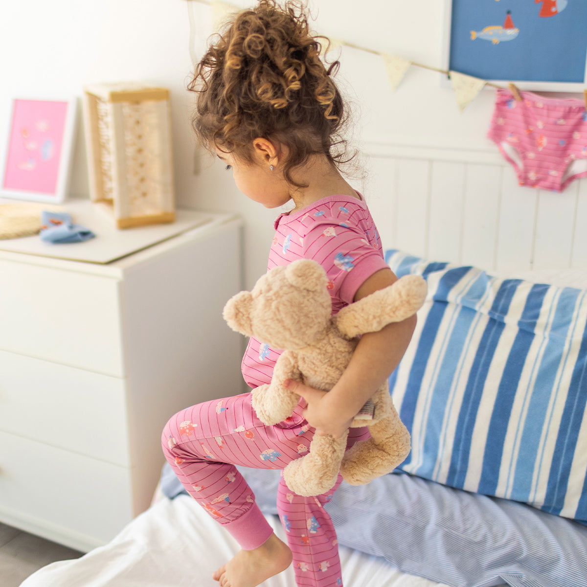 Pink one-piece pajamas with stripes and fish patterns, baby