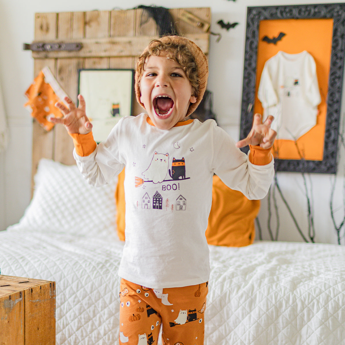 Photo d'un enfant portant le pyjama deux pièces crème et orange à motifs d’Halloween, enfant