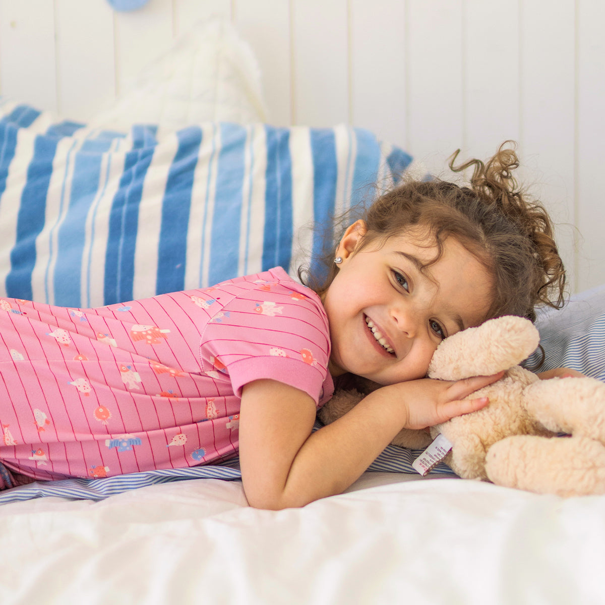 Pink one-piece pajamas with stripes and fish patterns, baby
