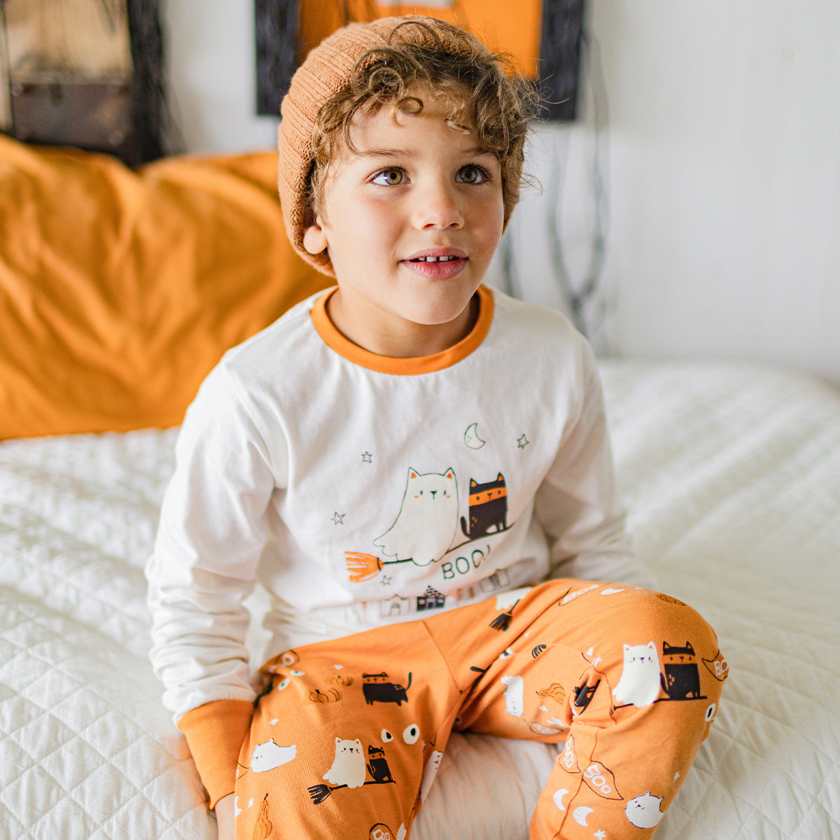 Photo d'un enfant portant le pyjama deux pièces crème et orange à motifs d’Halloween, enfant