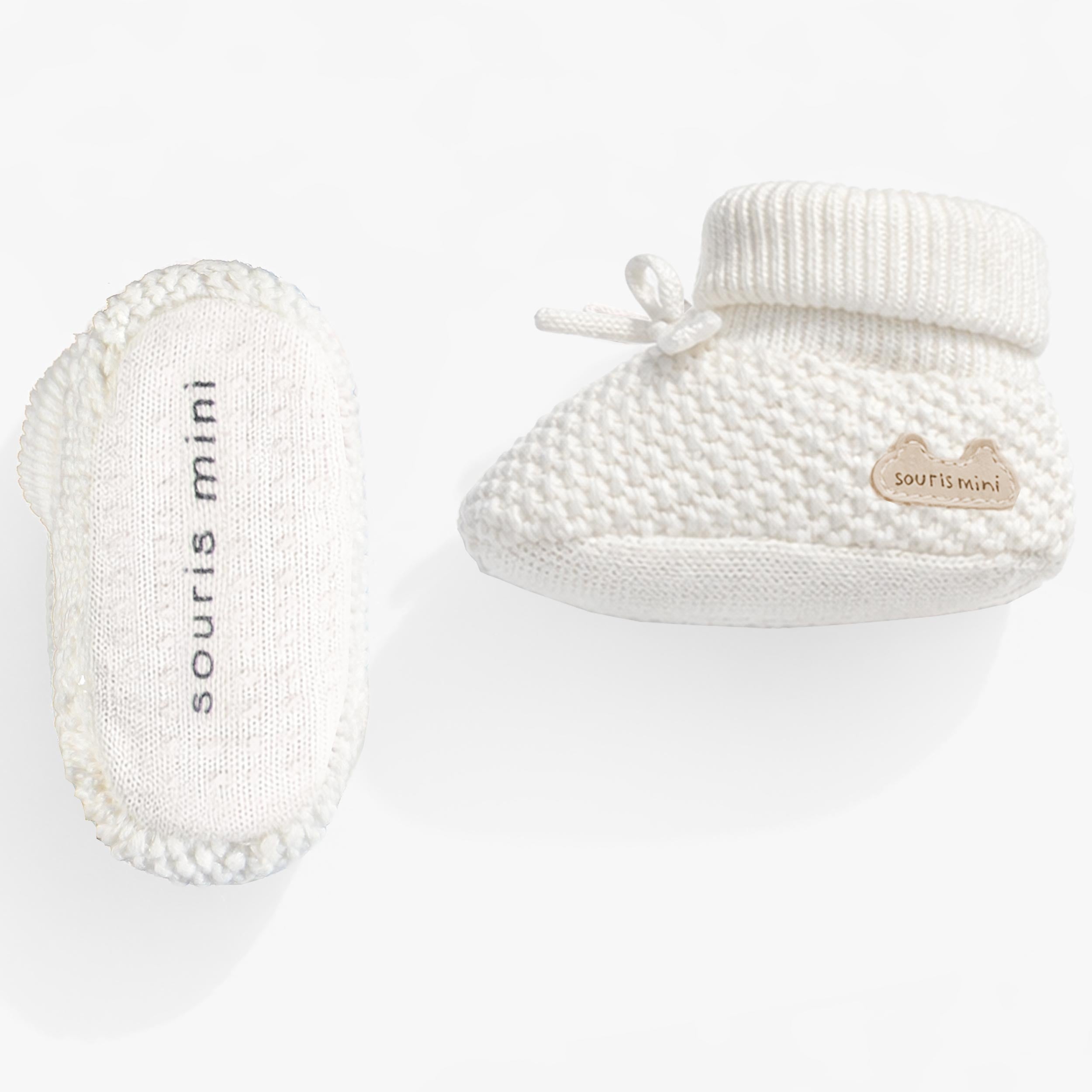 Vue de dessous et de côté des pantoufles crème en tricot, naissance