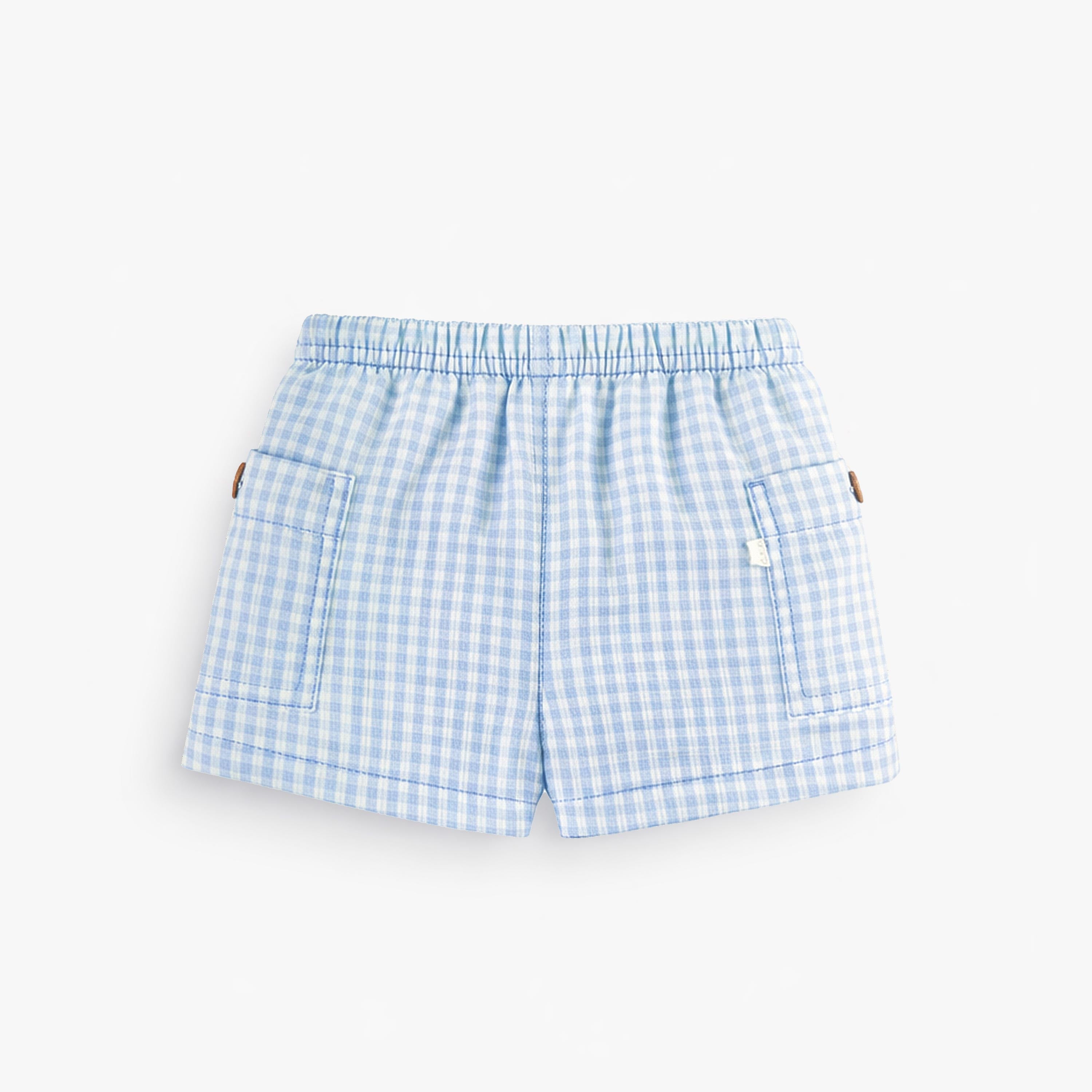 Dos du short bleu pâle à carreaux, naissance