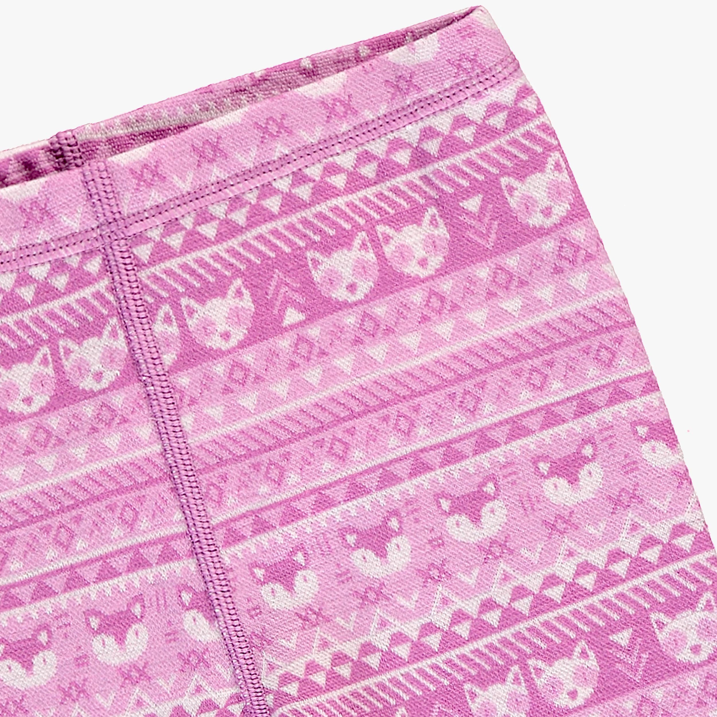 Gros plan des motifs sur un legging rose en laine mérinos pour bébé.