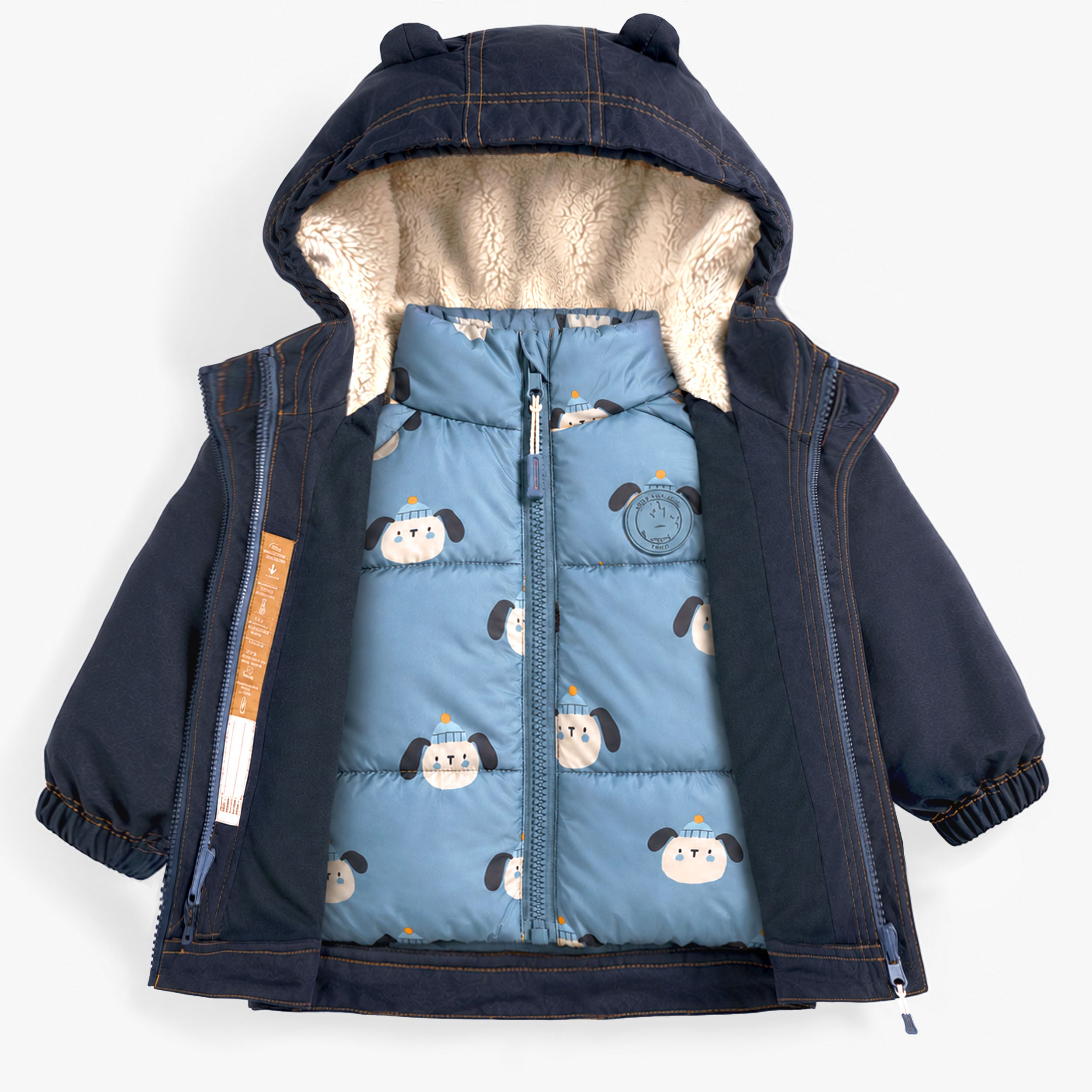 Vue rapprochée d’un manteau de neige bleu marine pour enfant ouvert révélant une doudoune intérieure amovible bleue à motif ludique et une doublure sherpa.