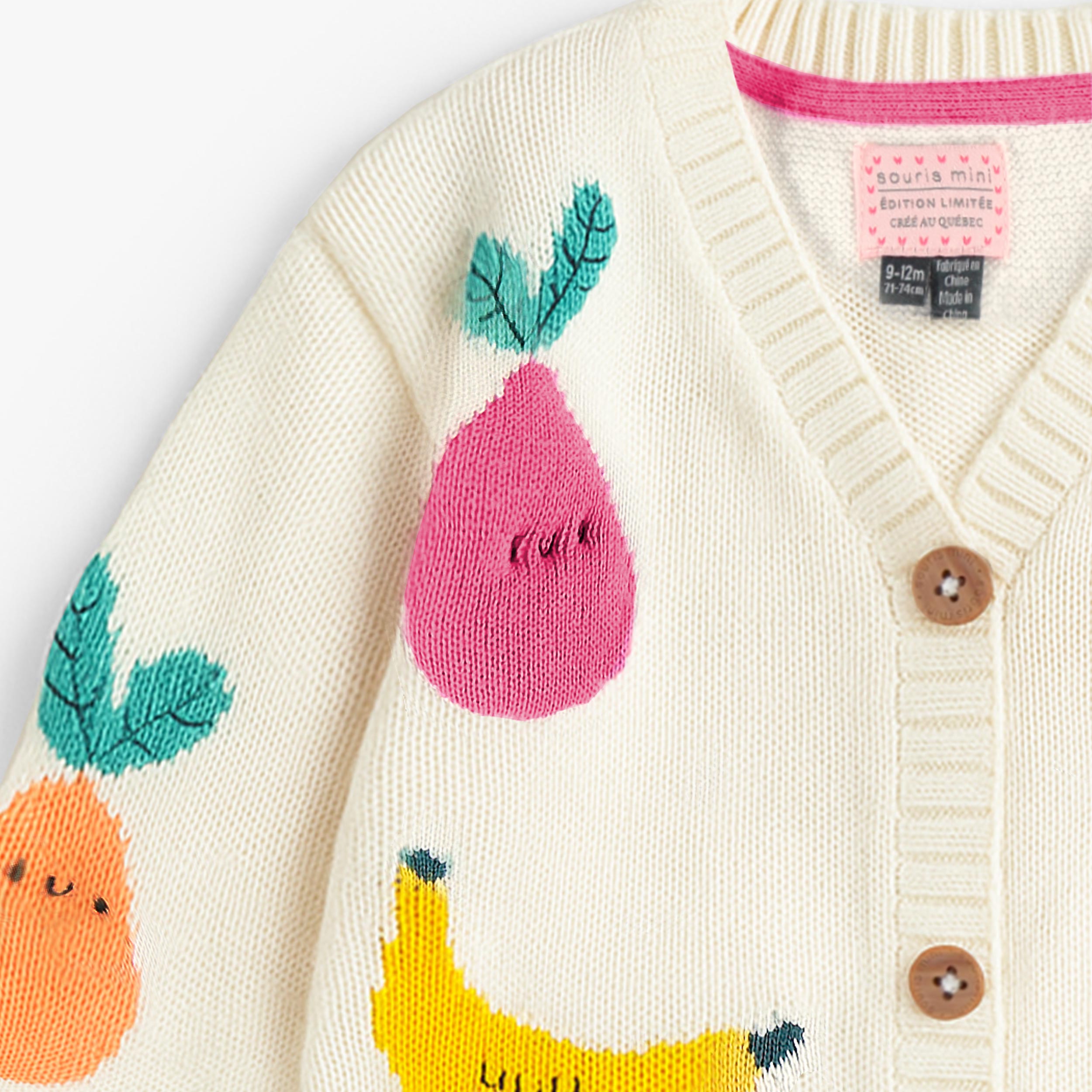 Zoom du cardigan crème en tricot avec motifs de fruits, bébé 