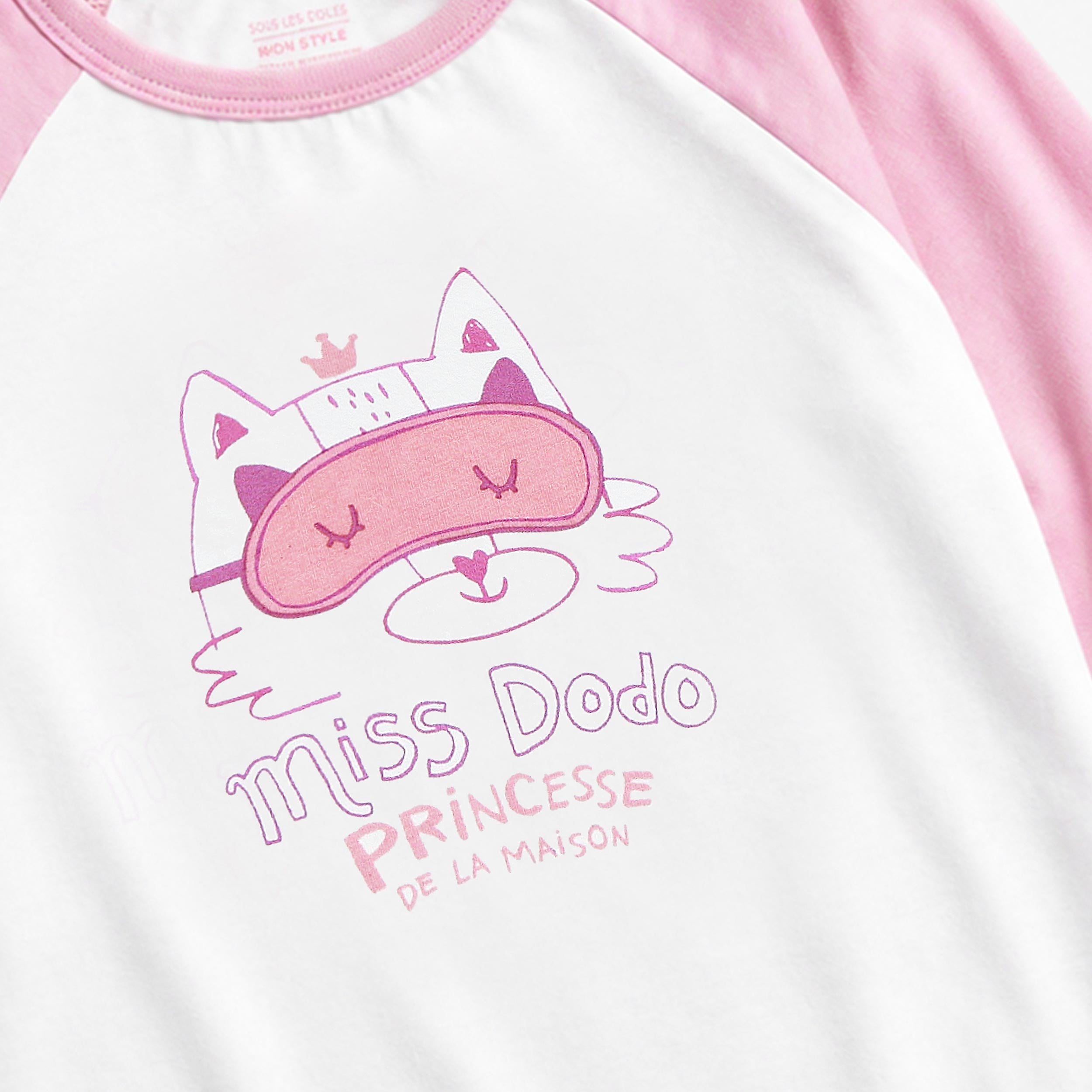 Gros plan de l’illustration de chat avec masque de sommeil sur le haut du pyjama rose en jersey de coton pour enfant.