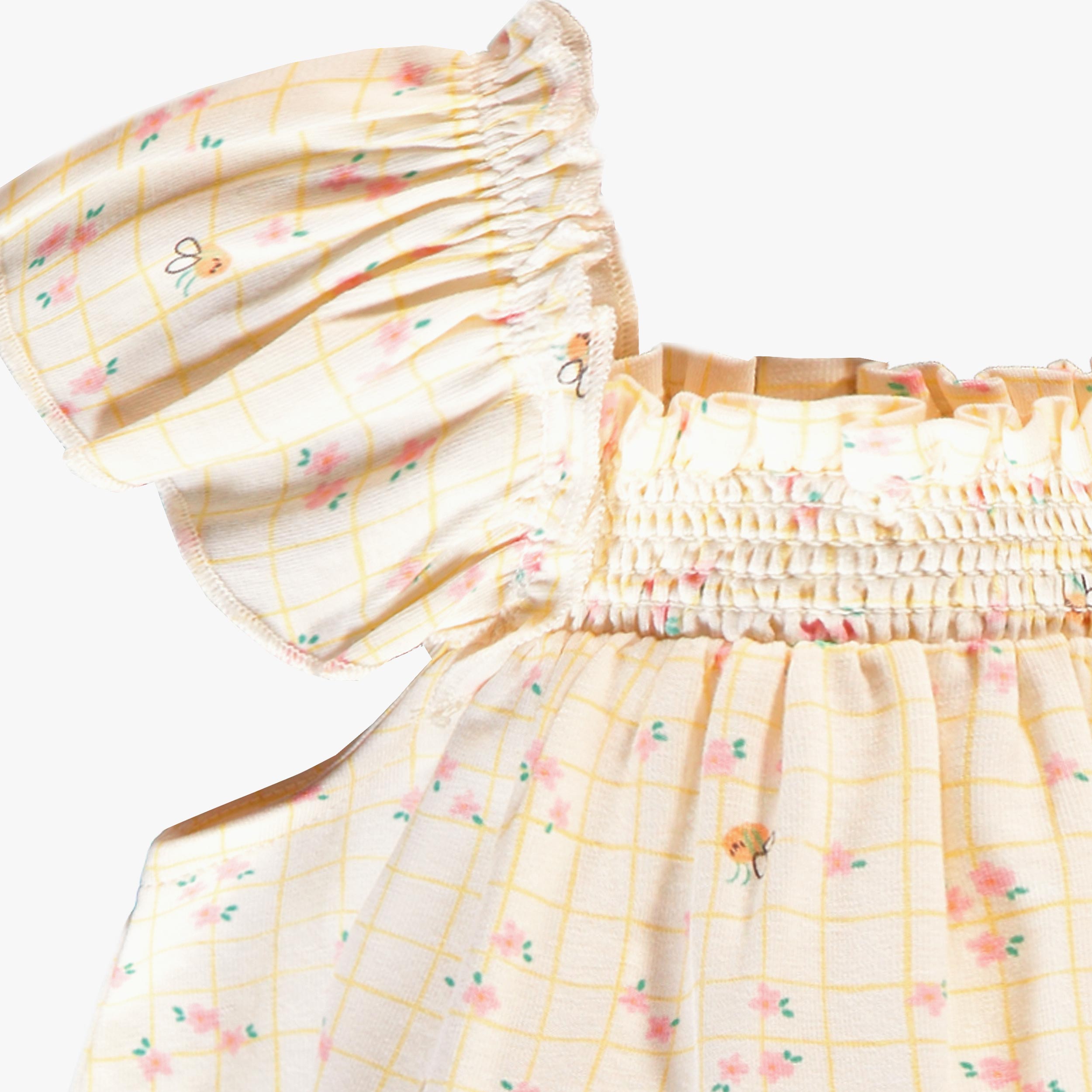 Zoom détails de la barboteuse crème à carreaux et motif floral, naissance