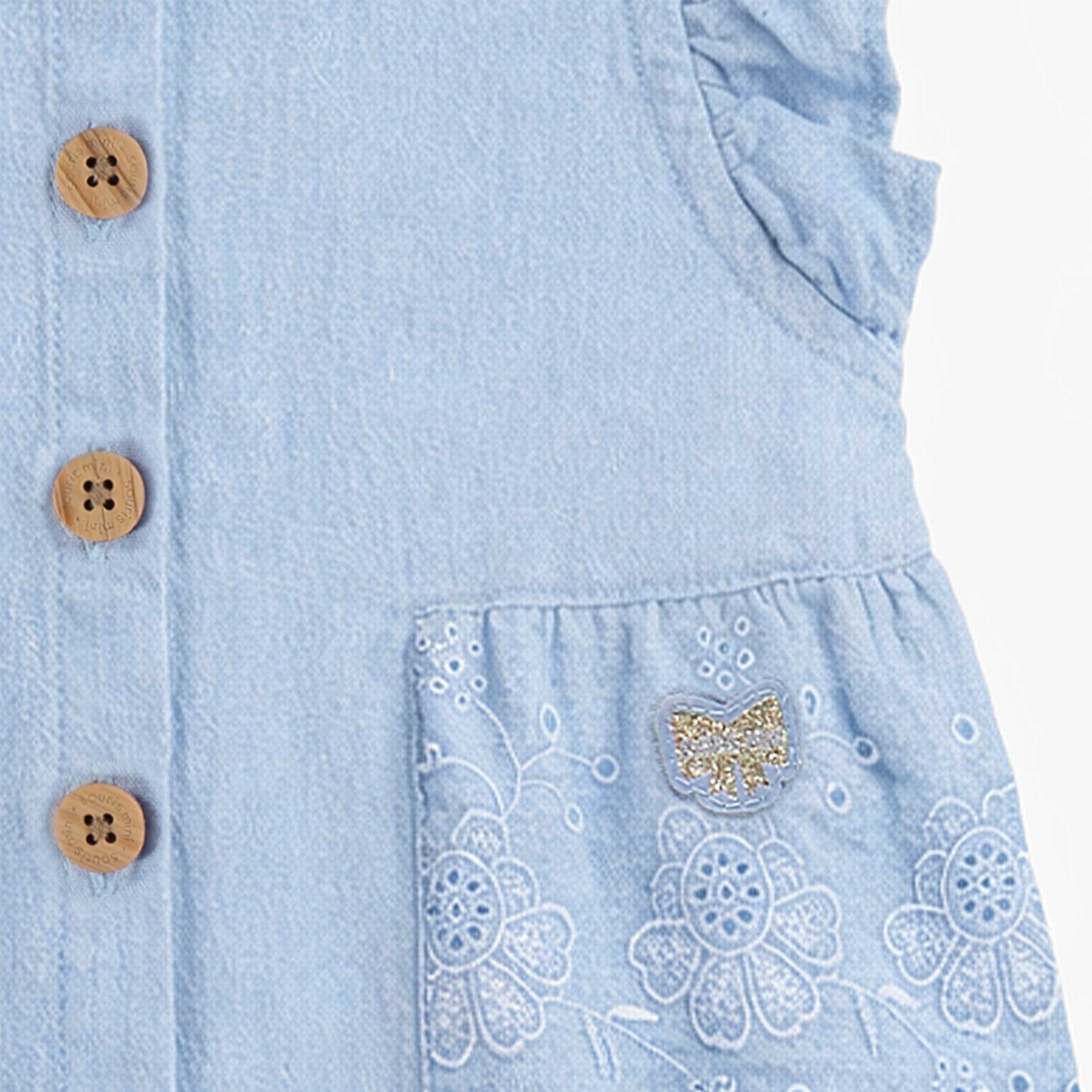Zoom détails de la blouse bleue avec broderie anglaise, bébé