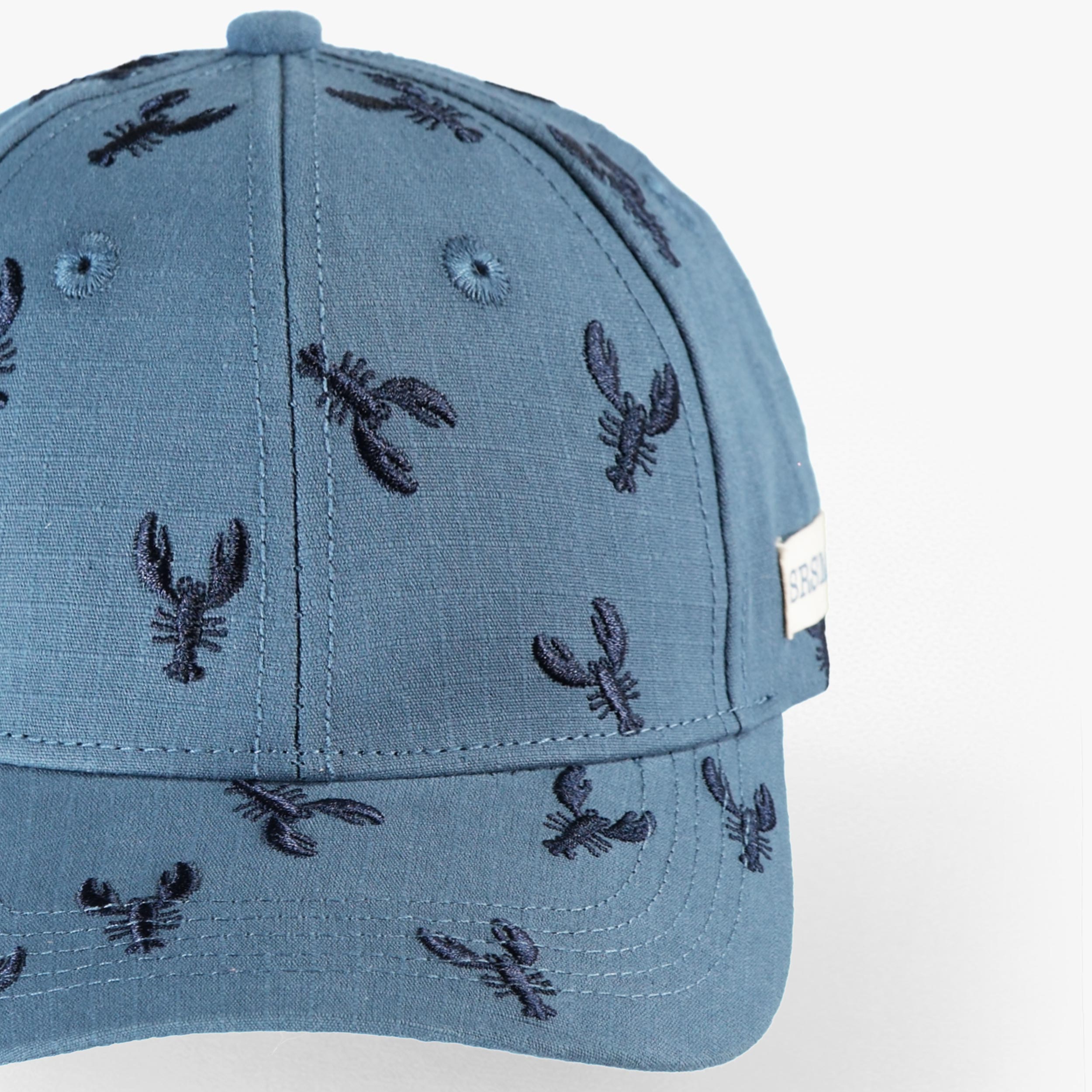 Zoom détails de la casquette bleue avec broderies de homards, bébé