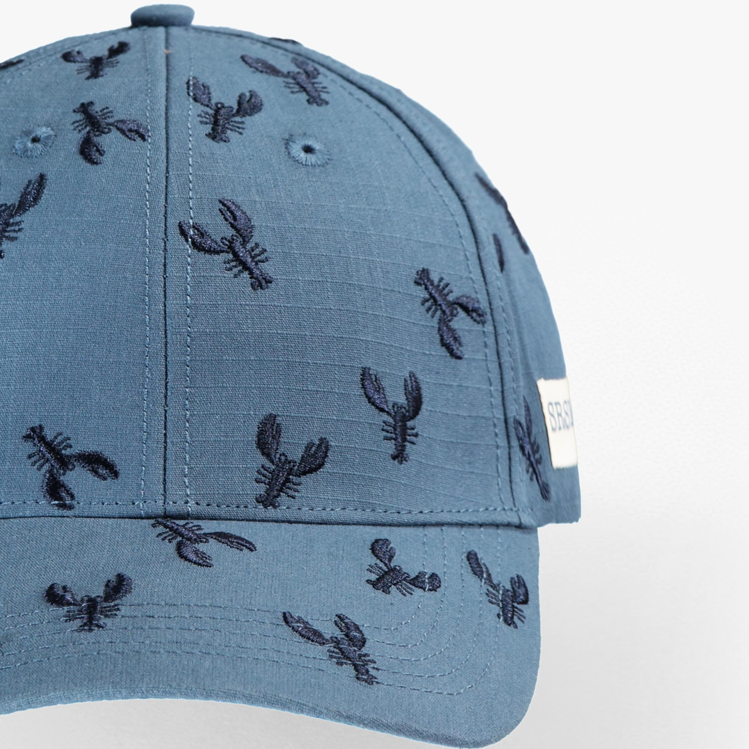 Zoom détails de la casquette bleue avec broderies de homards, enfant