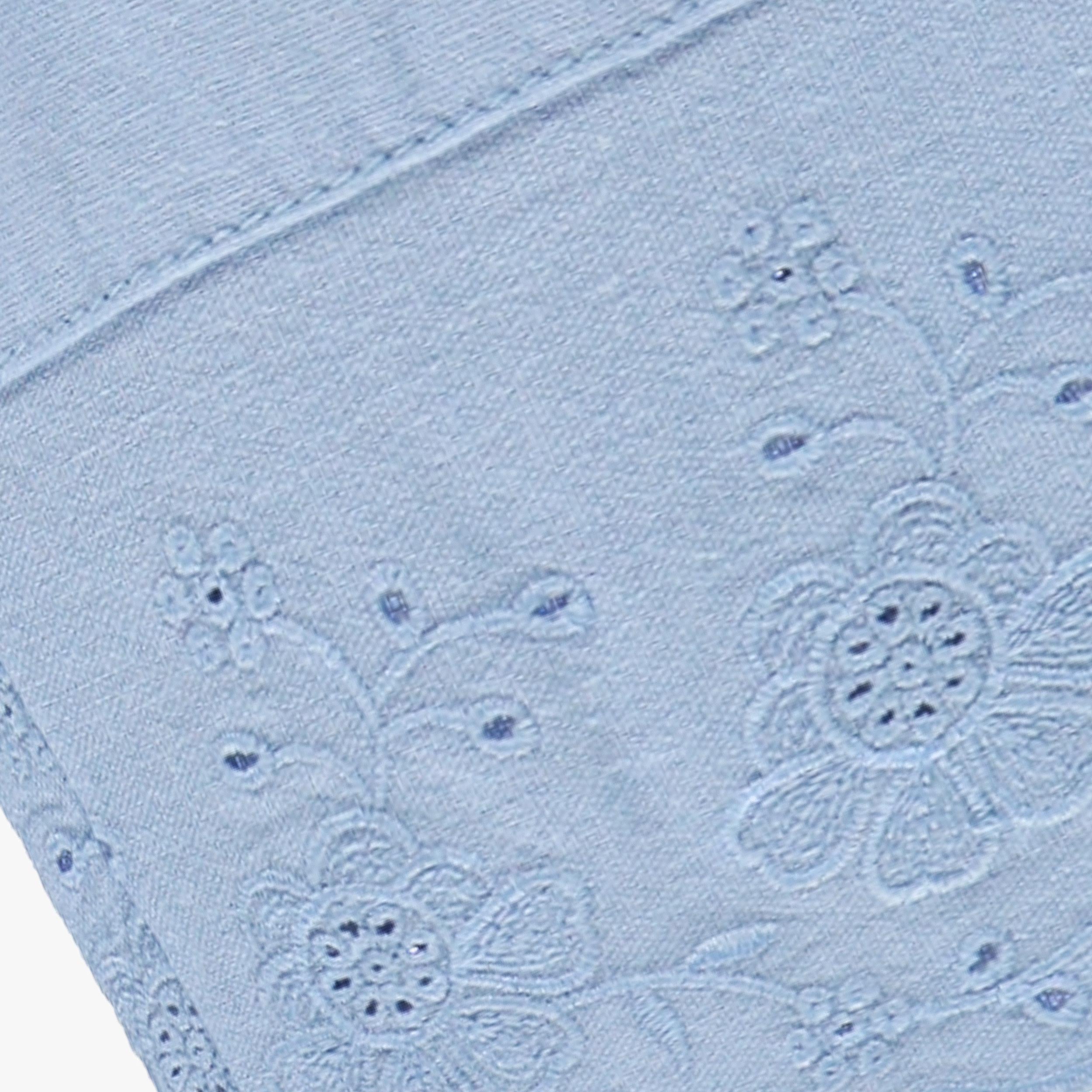 Zoom détails du pantalon bleu avec broderie anglaise, bébé