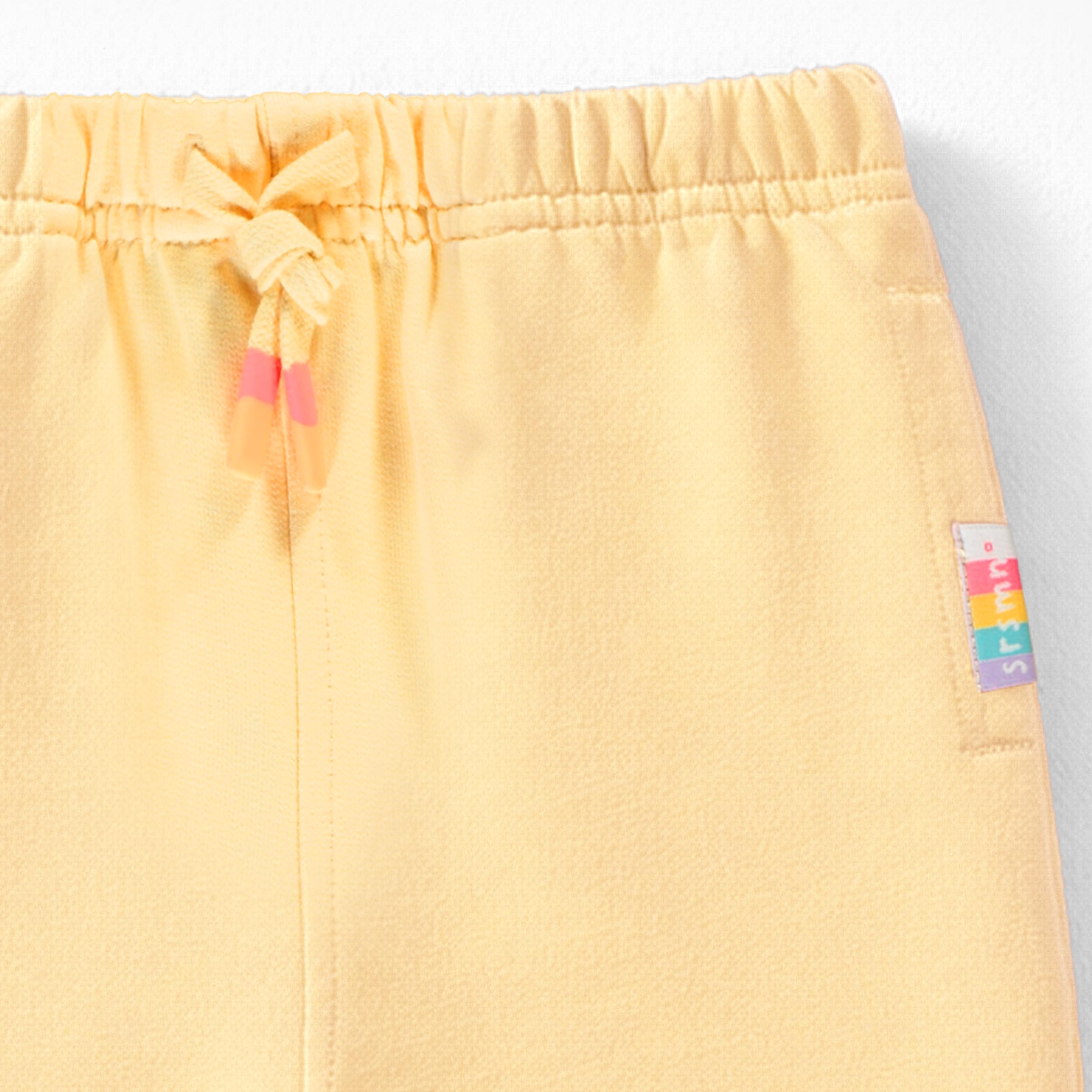 Zoom détails du pantalon jaune style jogger, bébé