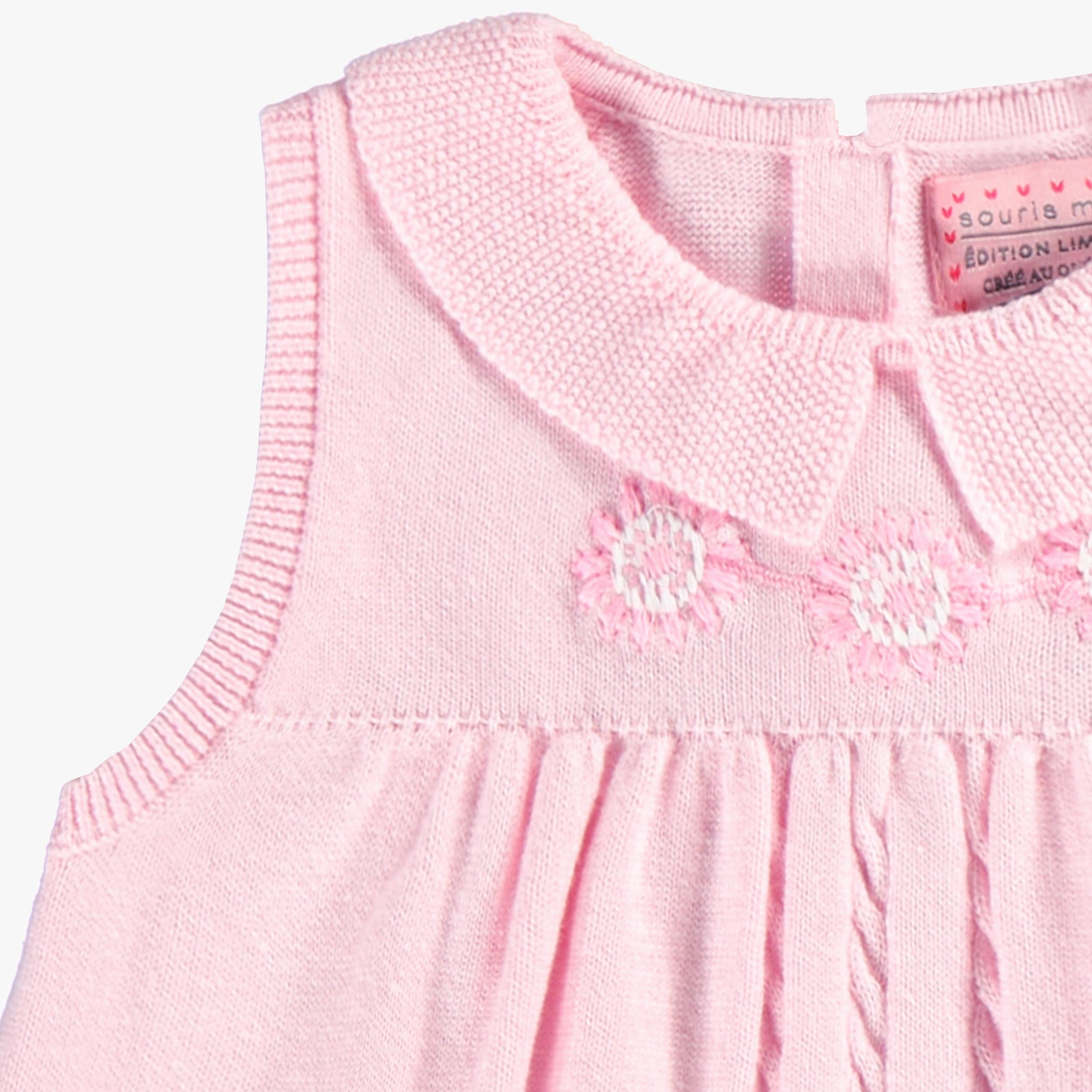 Zoom détails broderies de la robe rose en tricot, bébé