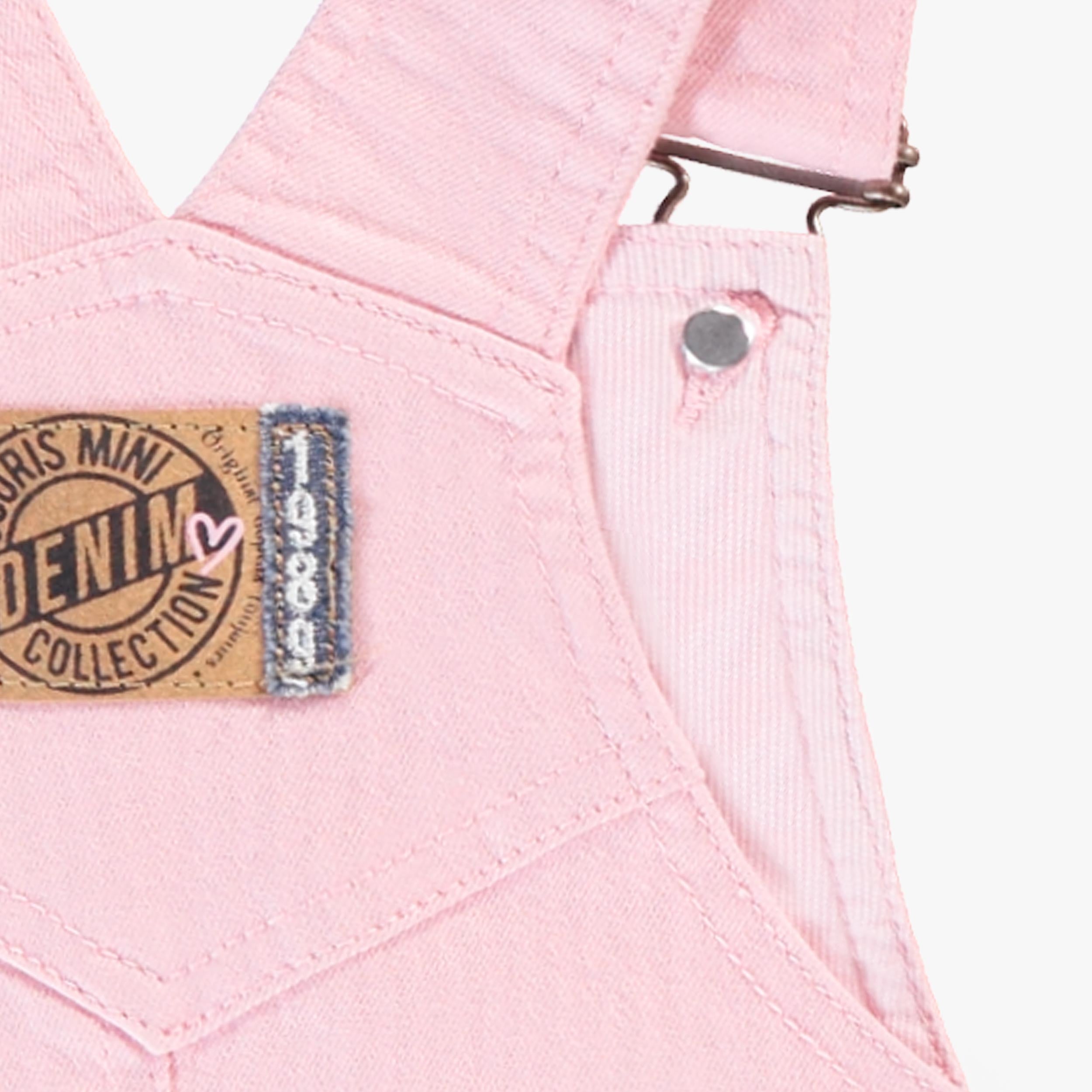 Zoom détails écusson dos de la salopette rose en denim, enfant